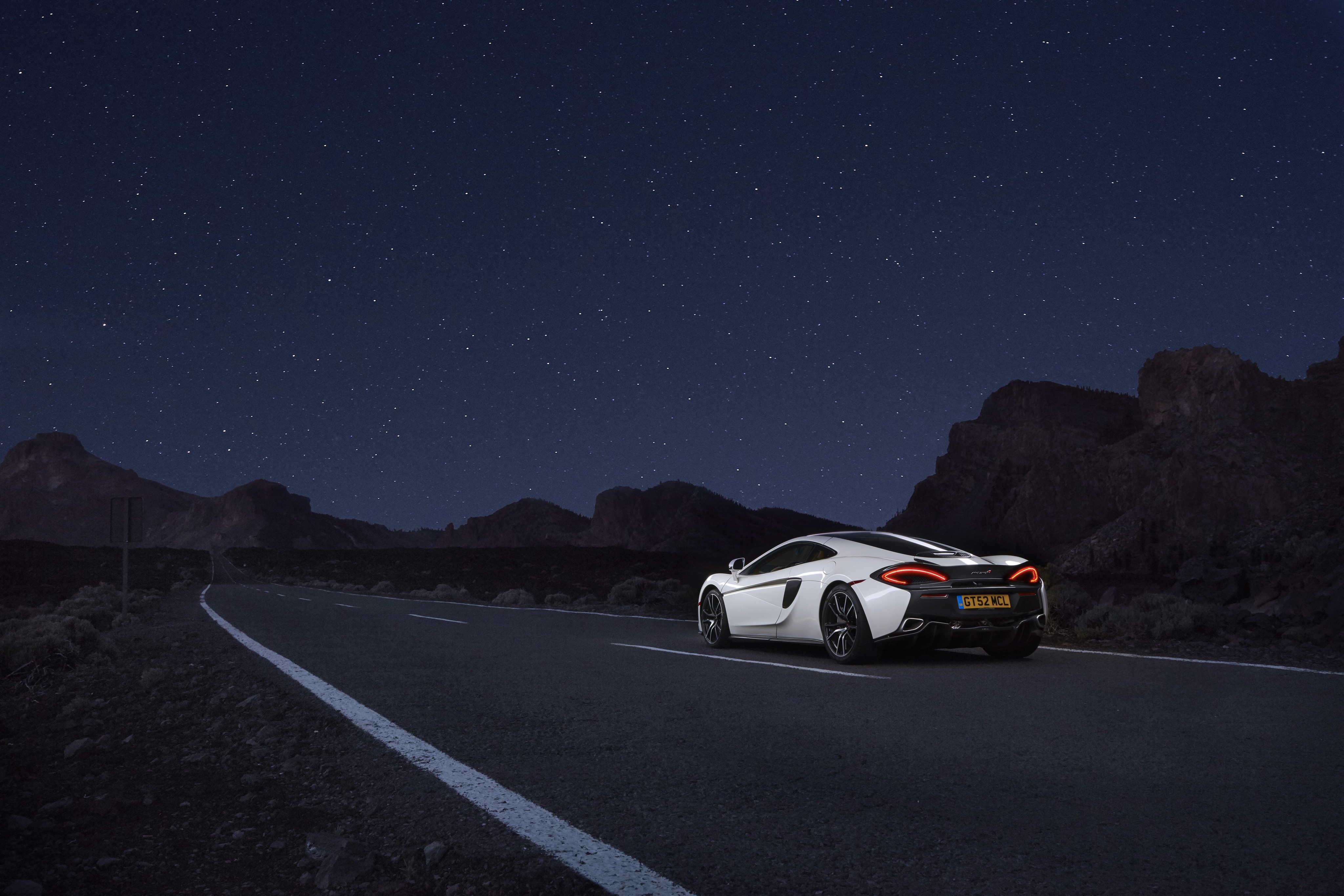 White McLaren 570GT on a road at night HD Wallpaper