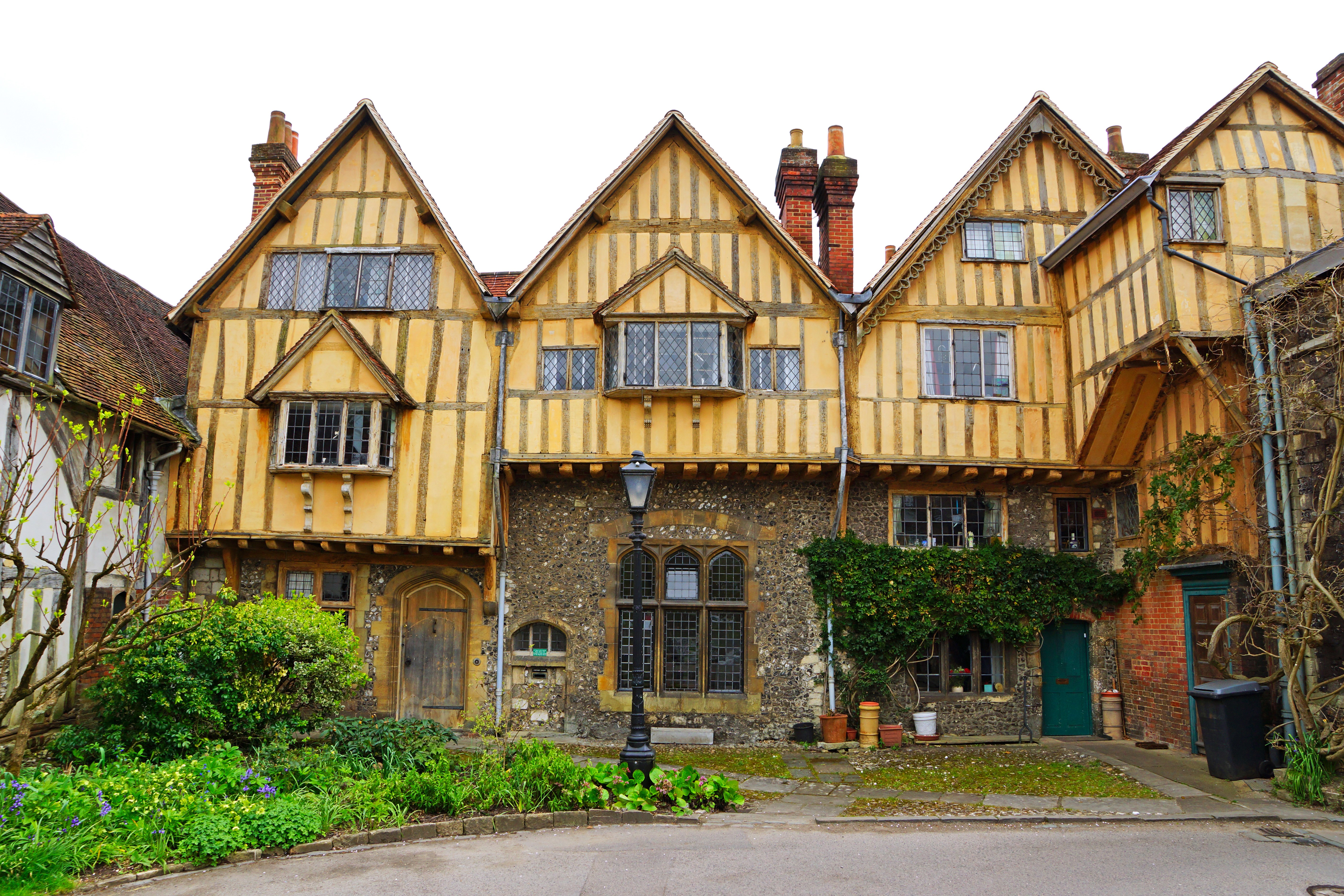 Timber-framed houses with shrubs and street lights in Winchester, England HD Wallpaper