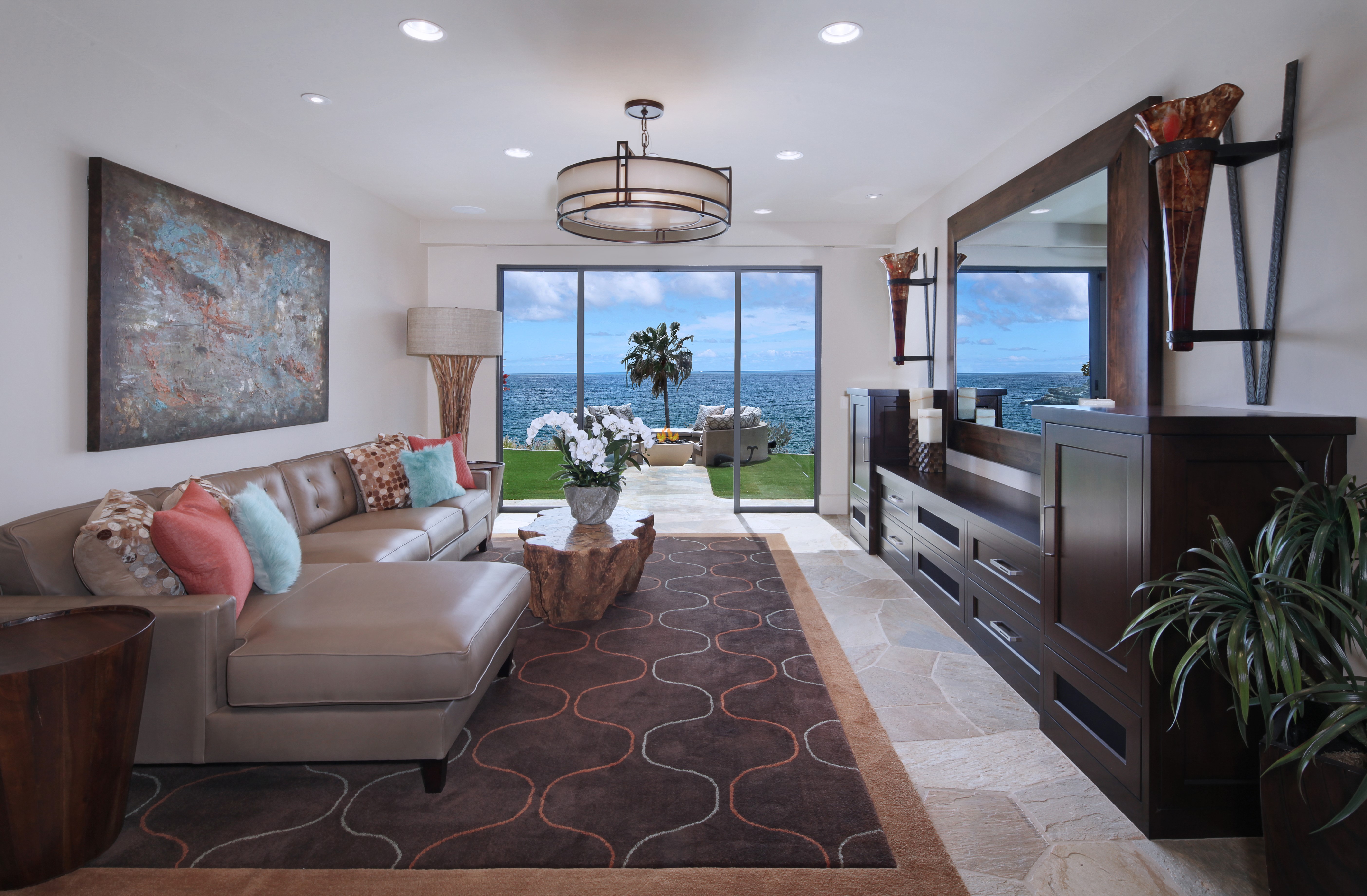 Living room with ocean view, sofa, chandelier, and carpet HD Wallpaper