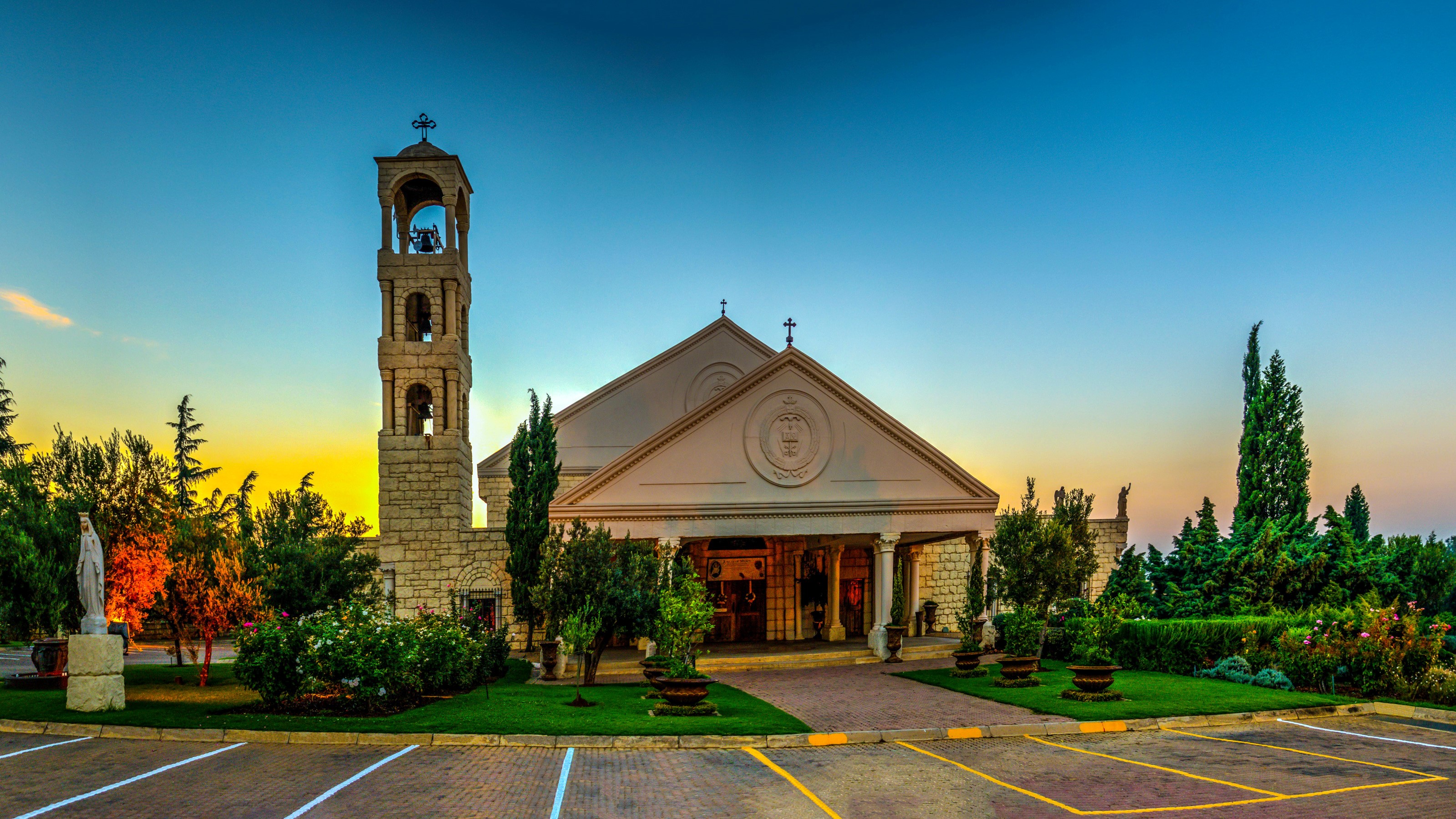 Church with bell tower and statue at sunset HD Wallpaper
