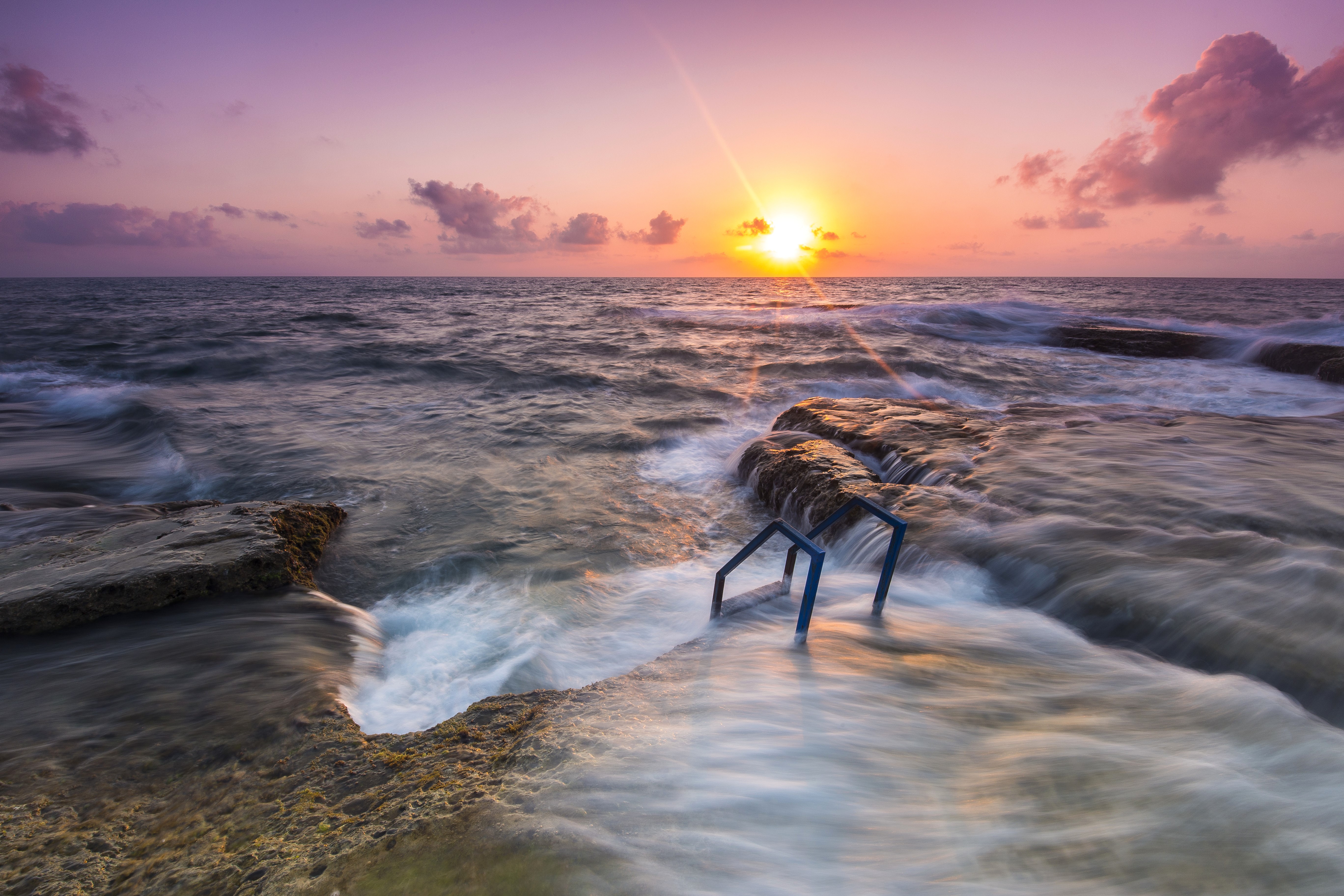 Sunrise over the sea with rocky shore and ladder HD Wallpaper