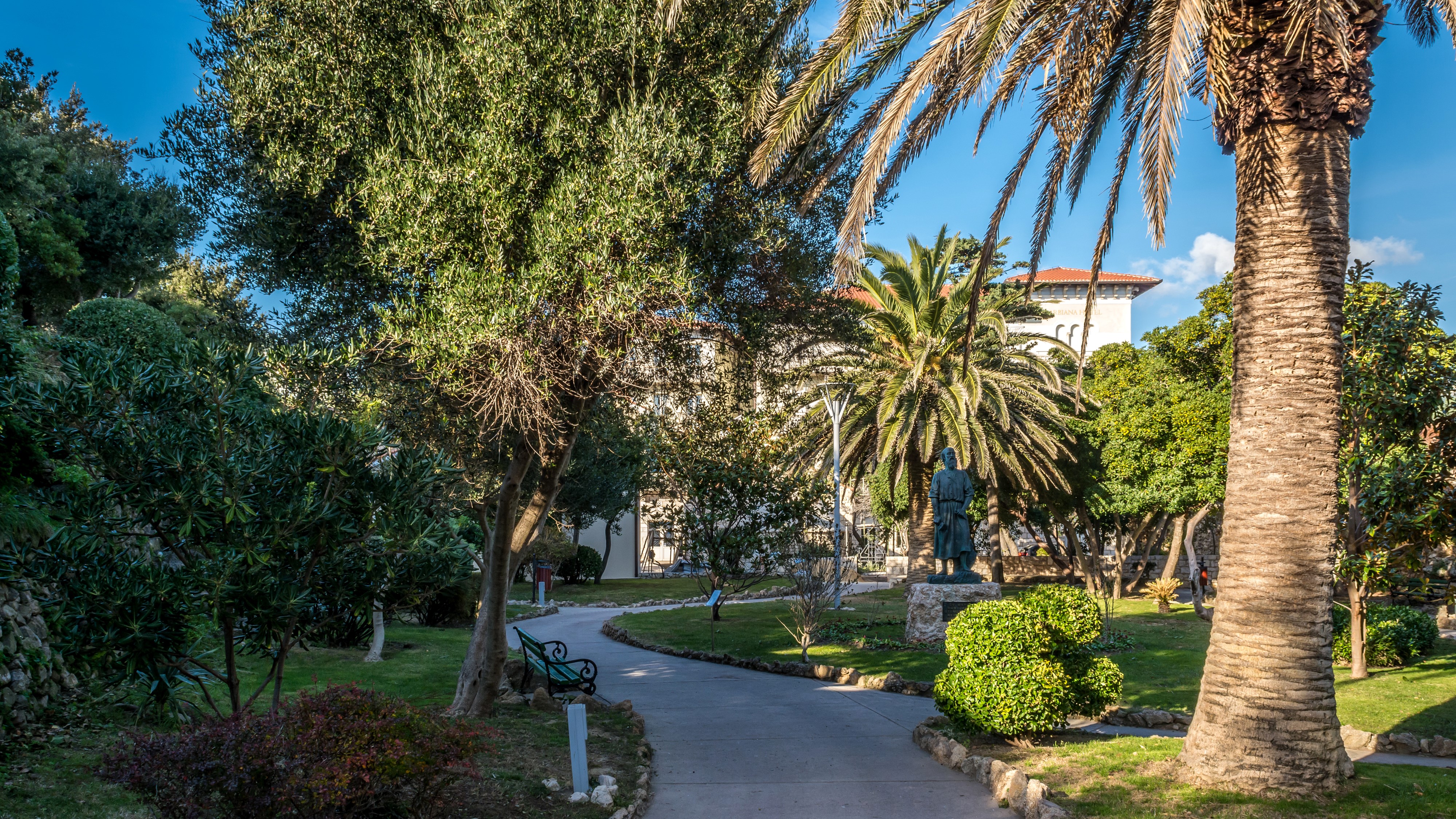 Park with statue and palm trees in Croatia HD Wallpaper