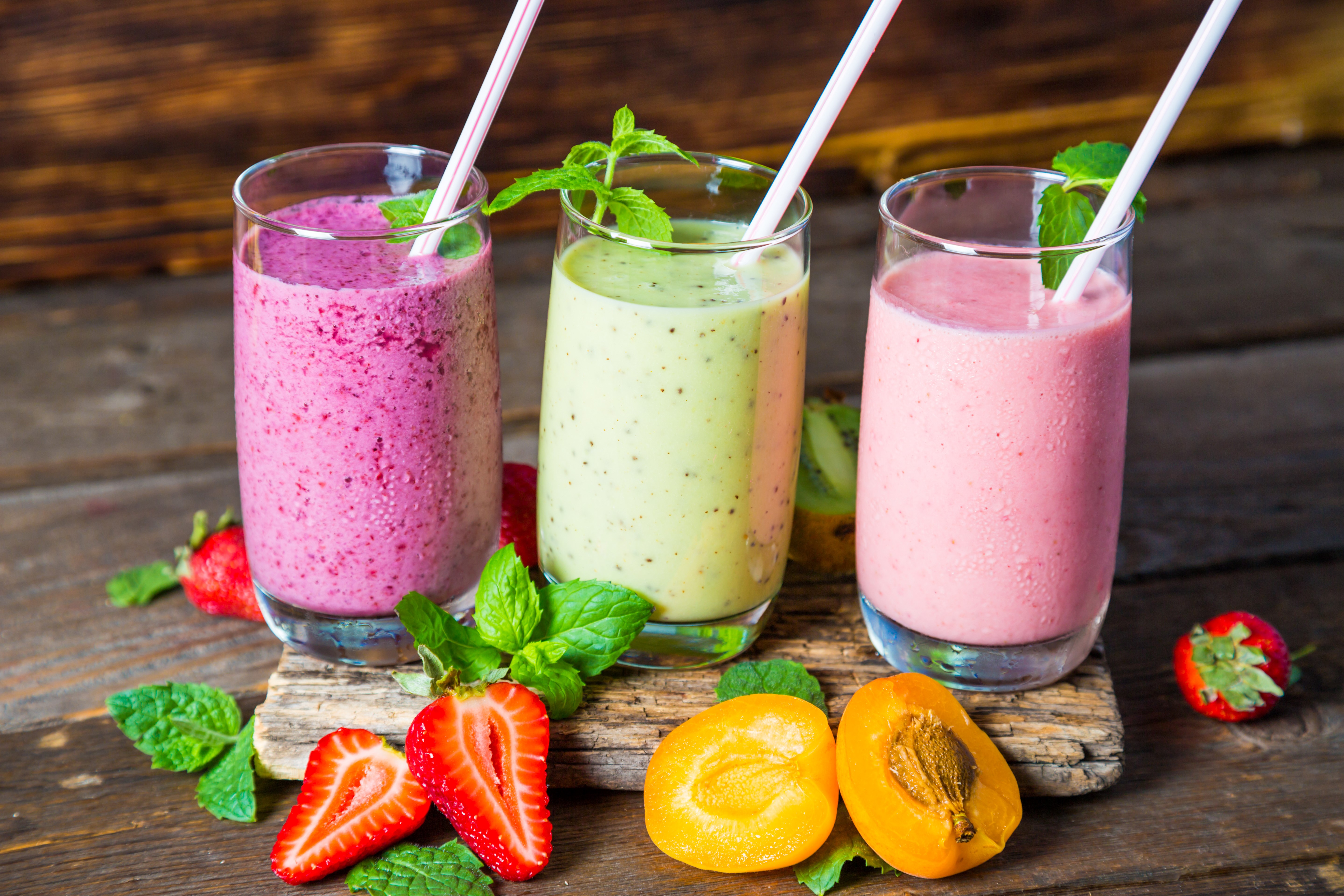 Three colorful fruit smoothies with strawberries and apricots HD Wallpaper
