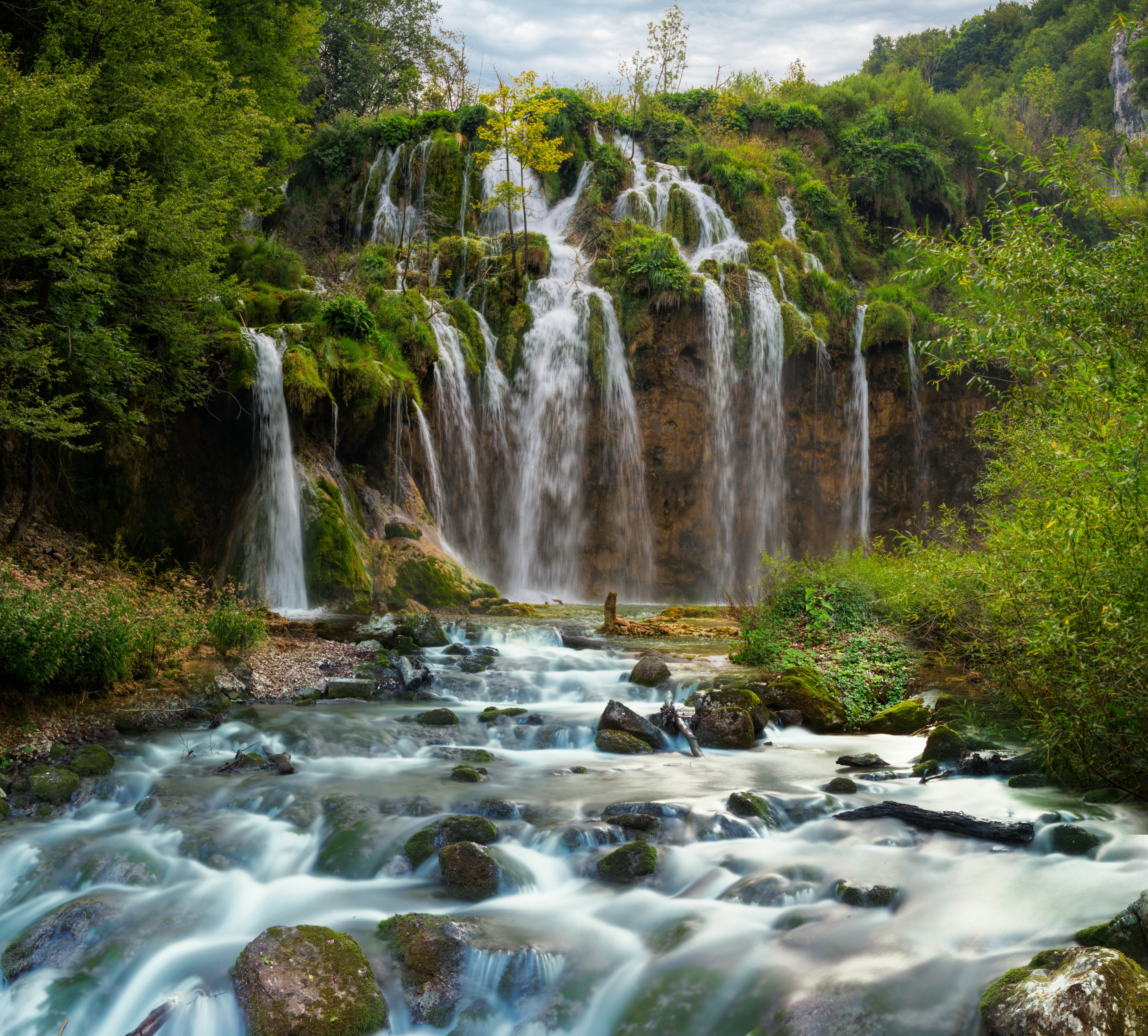 Waterfalls cascading over mossy rocks in Plitvice National Park, Croatia HD Wallpaper
