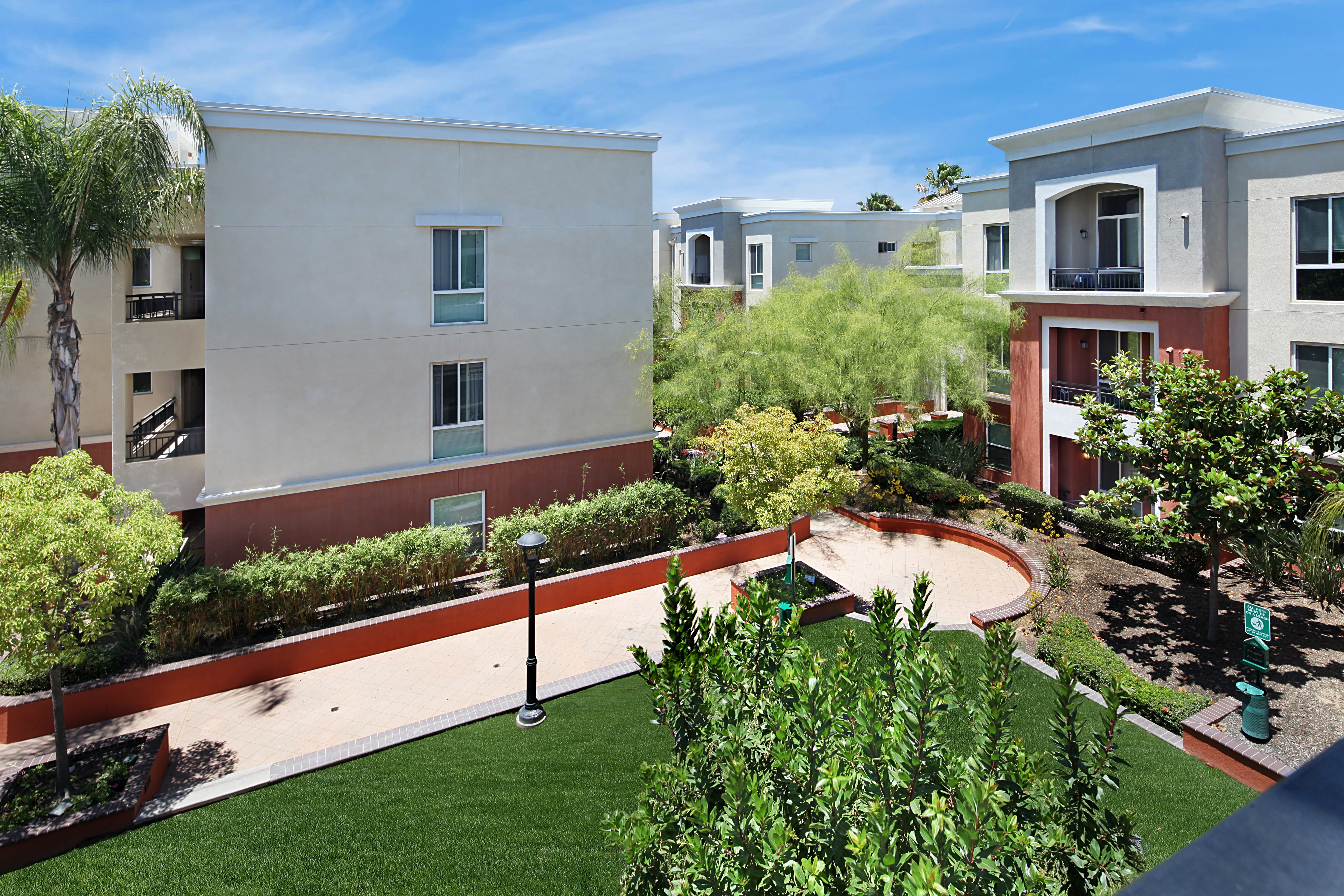Apartment buildings with courtyard and lawn in California HD Wallpaper