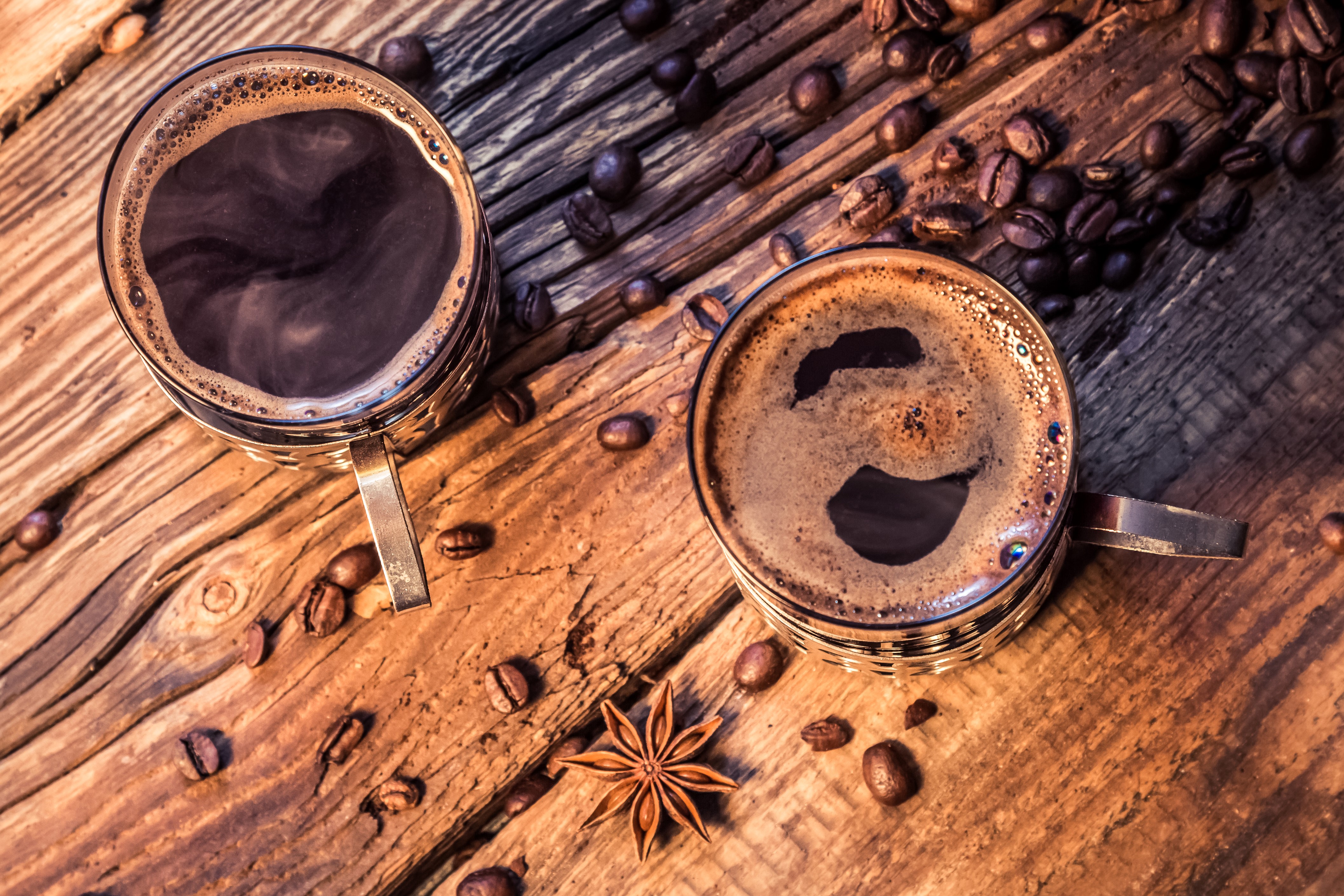 Two cups of coffee with coffee beans and star anise HD Wallpaper