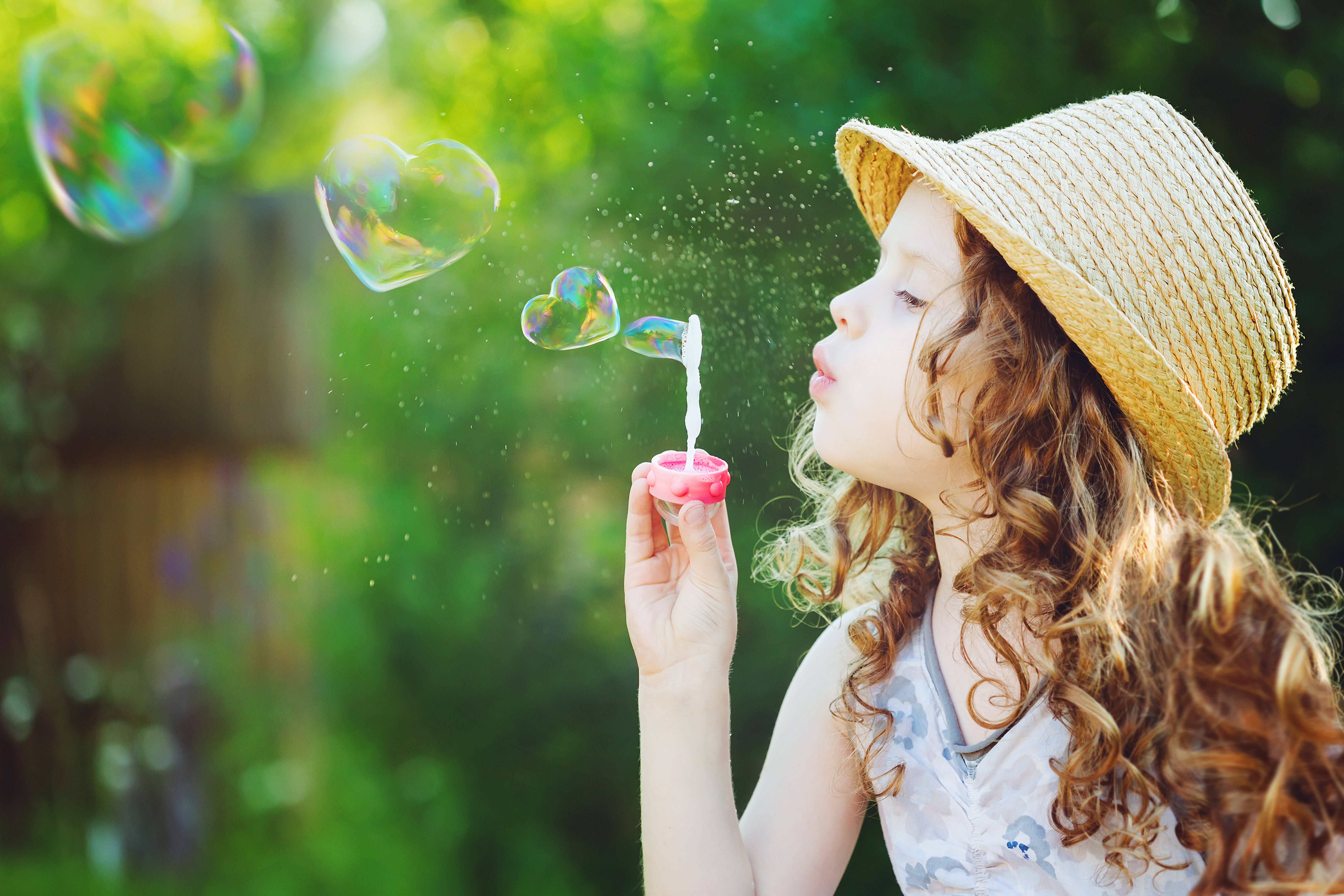Girl blowing heart-shaped bubbles HD Wallpaper