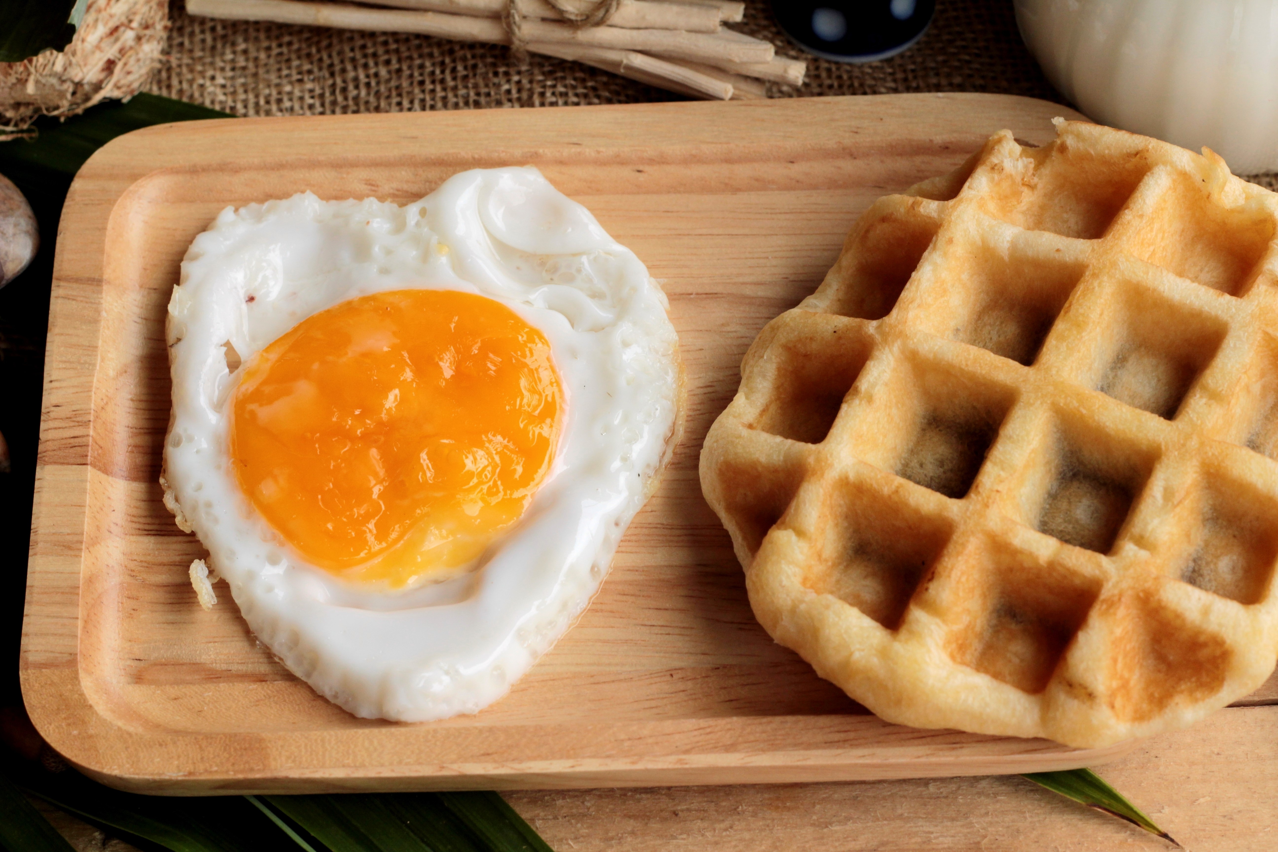 Fried egg and waffle on a wooden plate HD Wallpaper