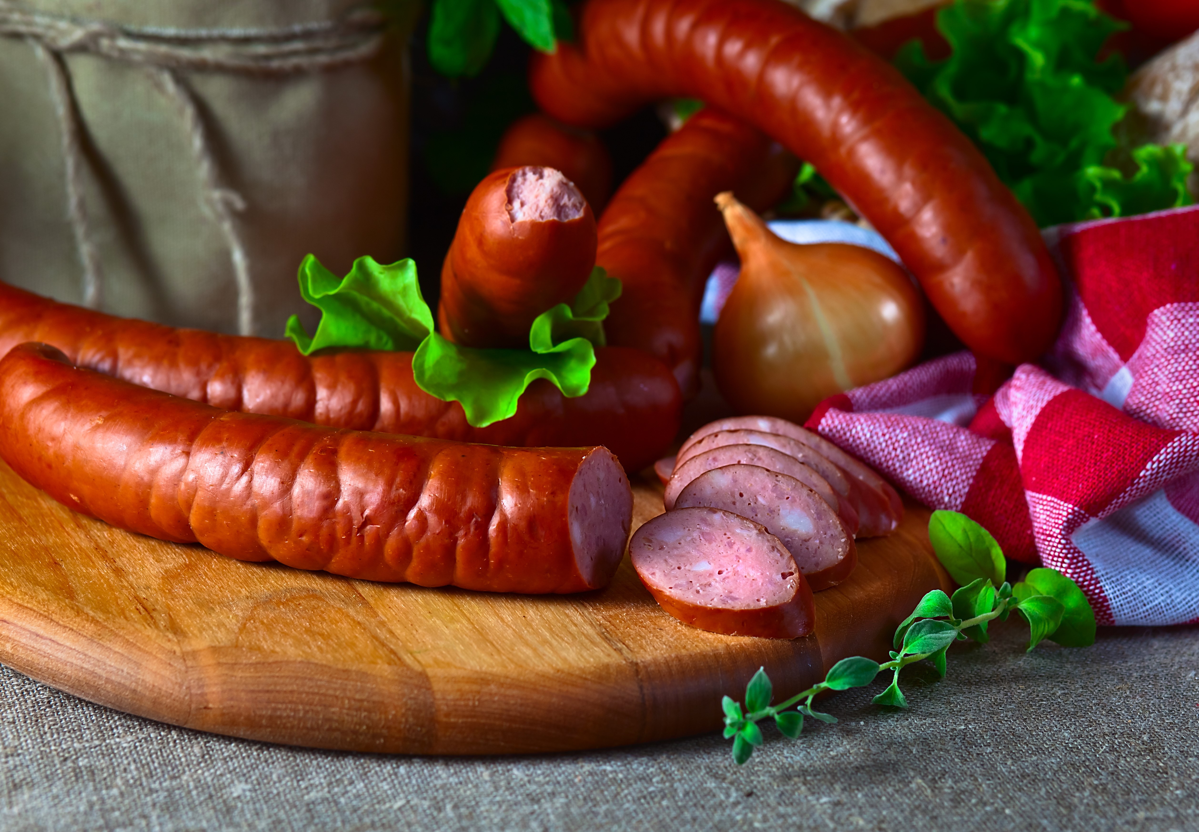 Sausages and onion on a wooden board HD Wallpaper
