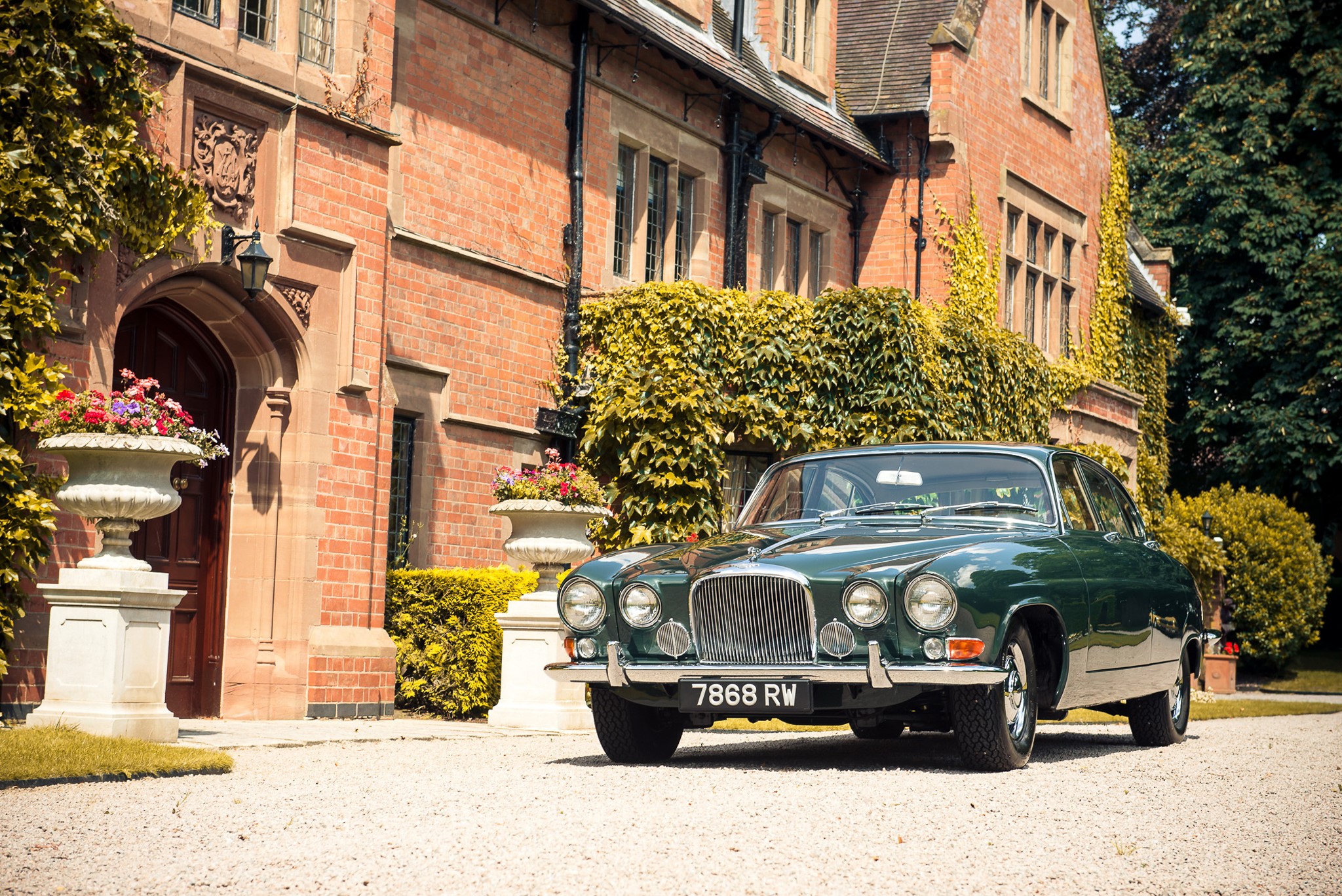 Green Jaguar Mark X parked in front of a brick mansion HD Wallpaper