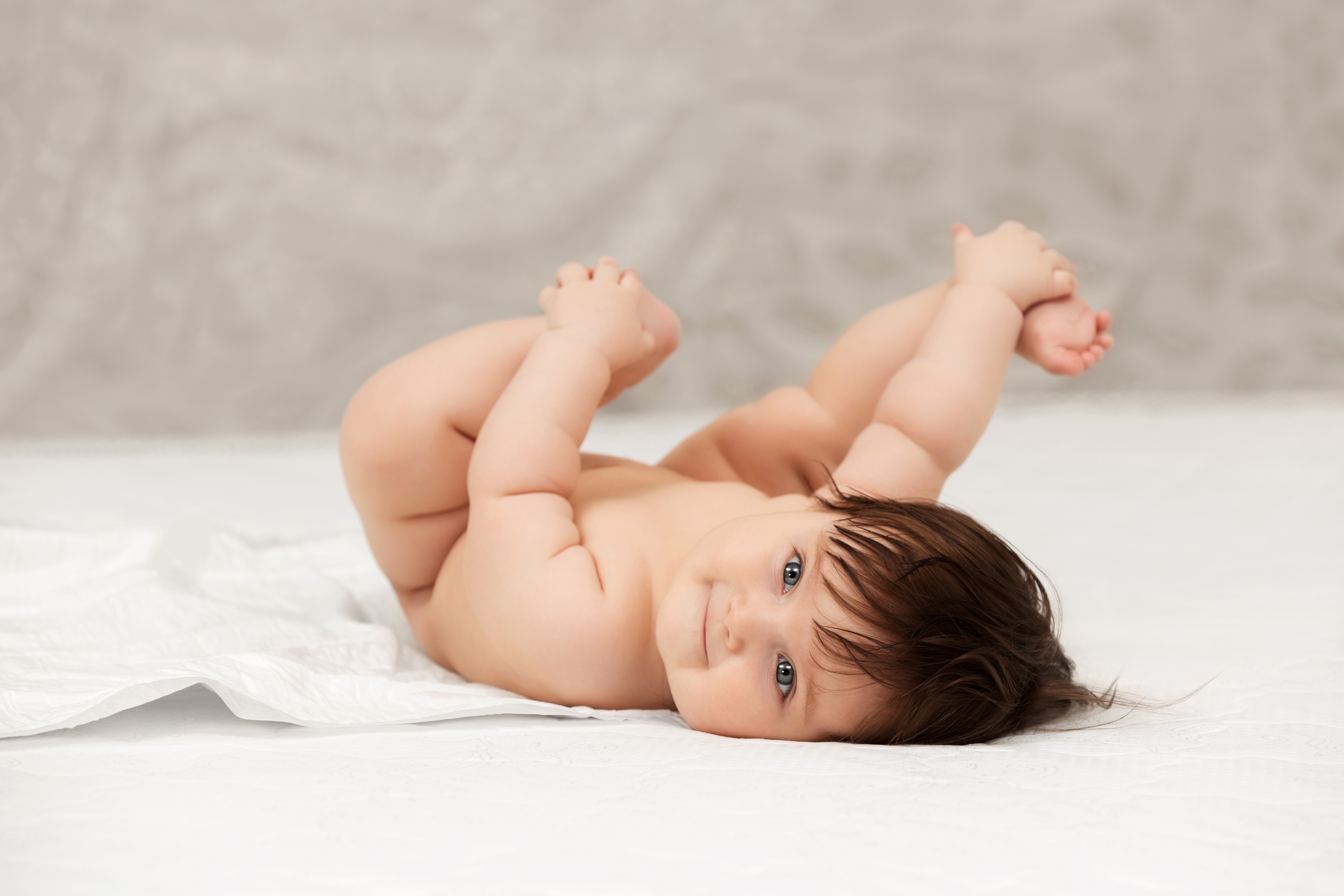 Baby lying on back with legs up HD Wallpaper