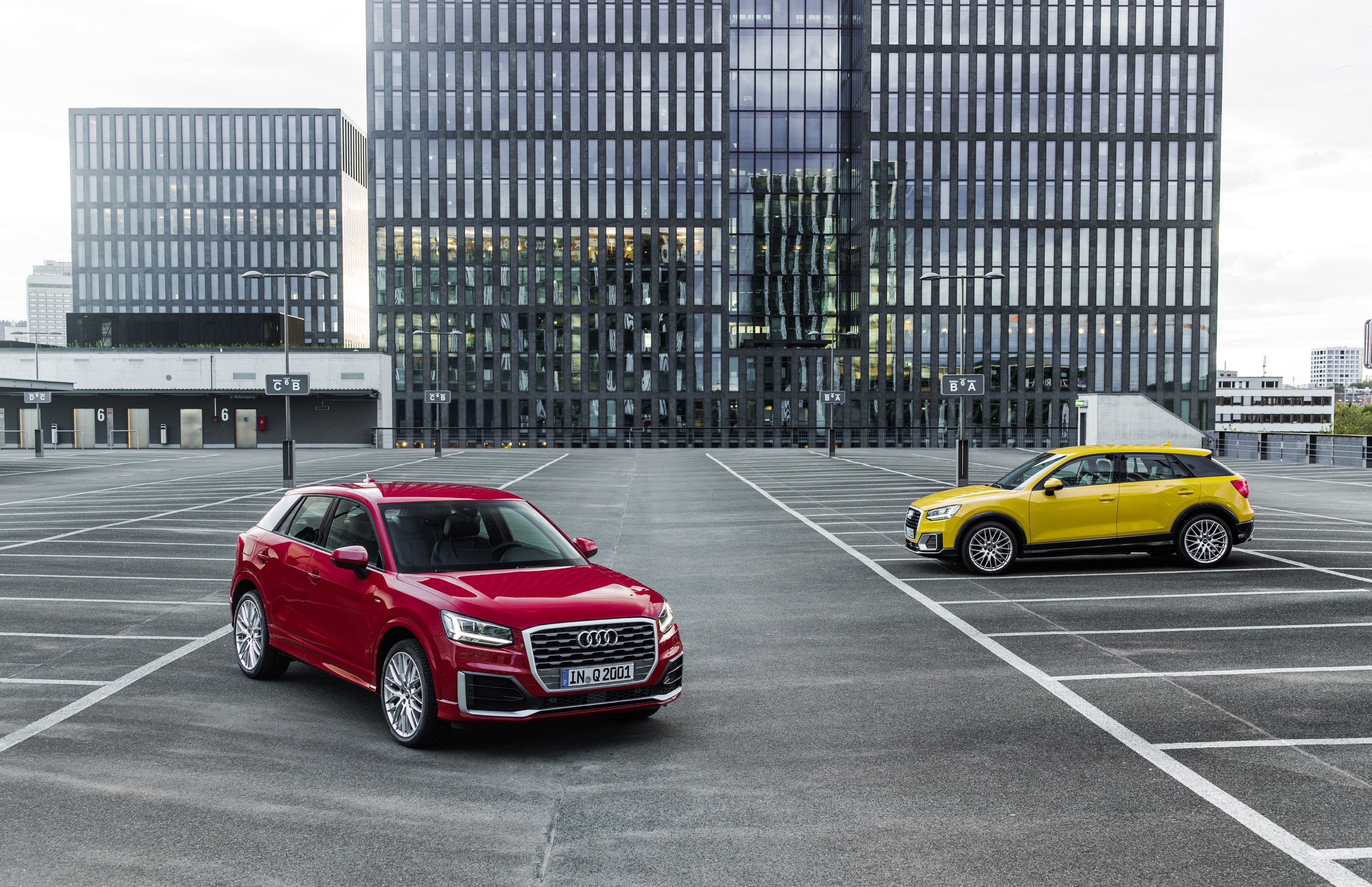 Two Audi Q2 cars in a parking lot HD Wallpaper