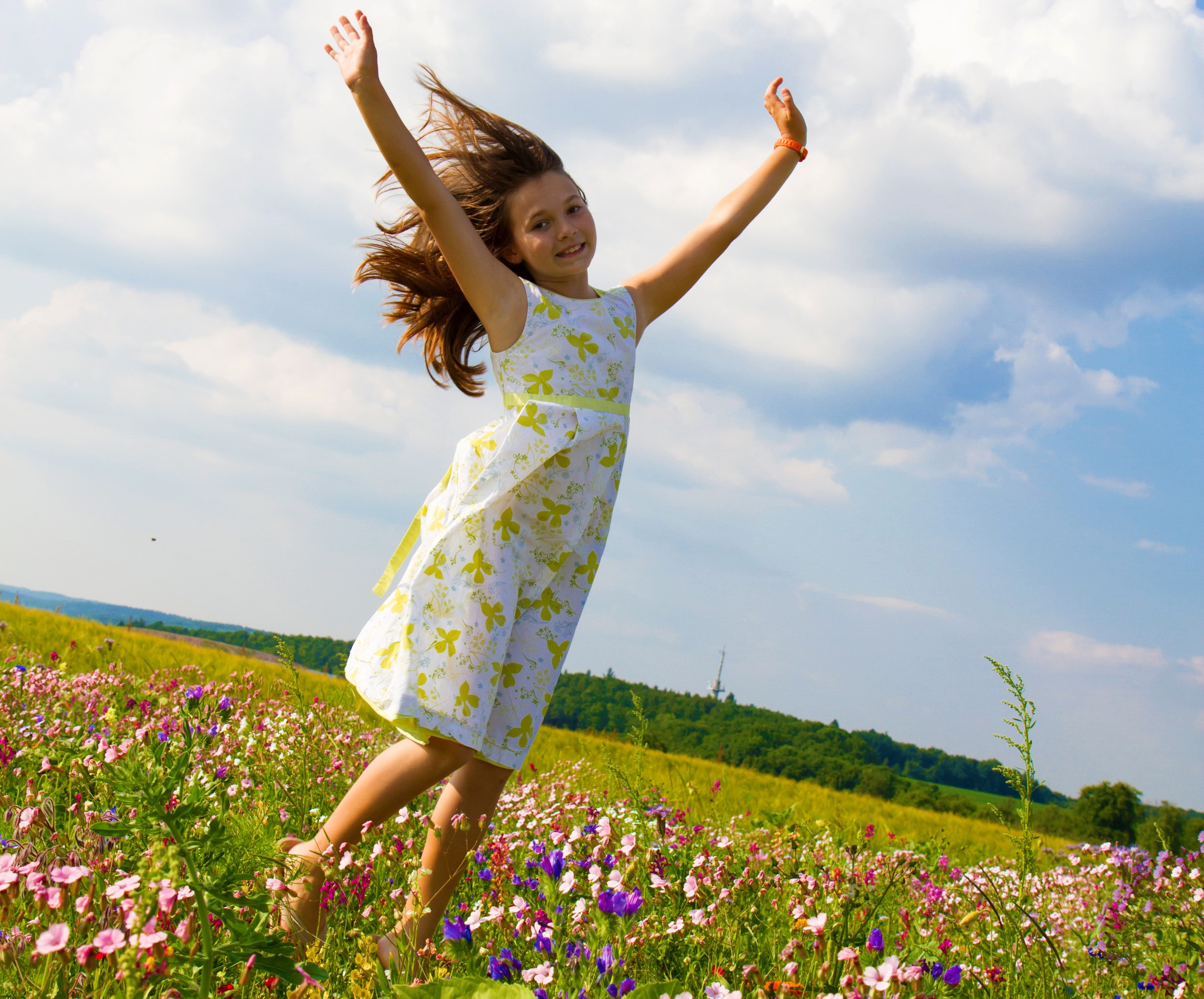 Girl jumping in a field of flowers HD Wallpaper
