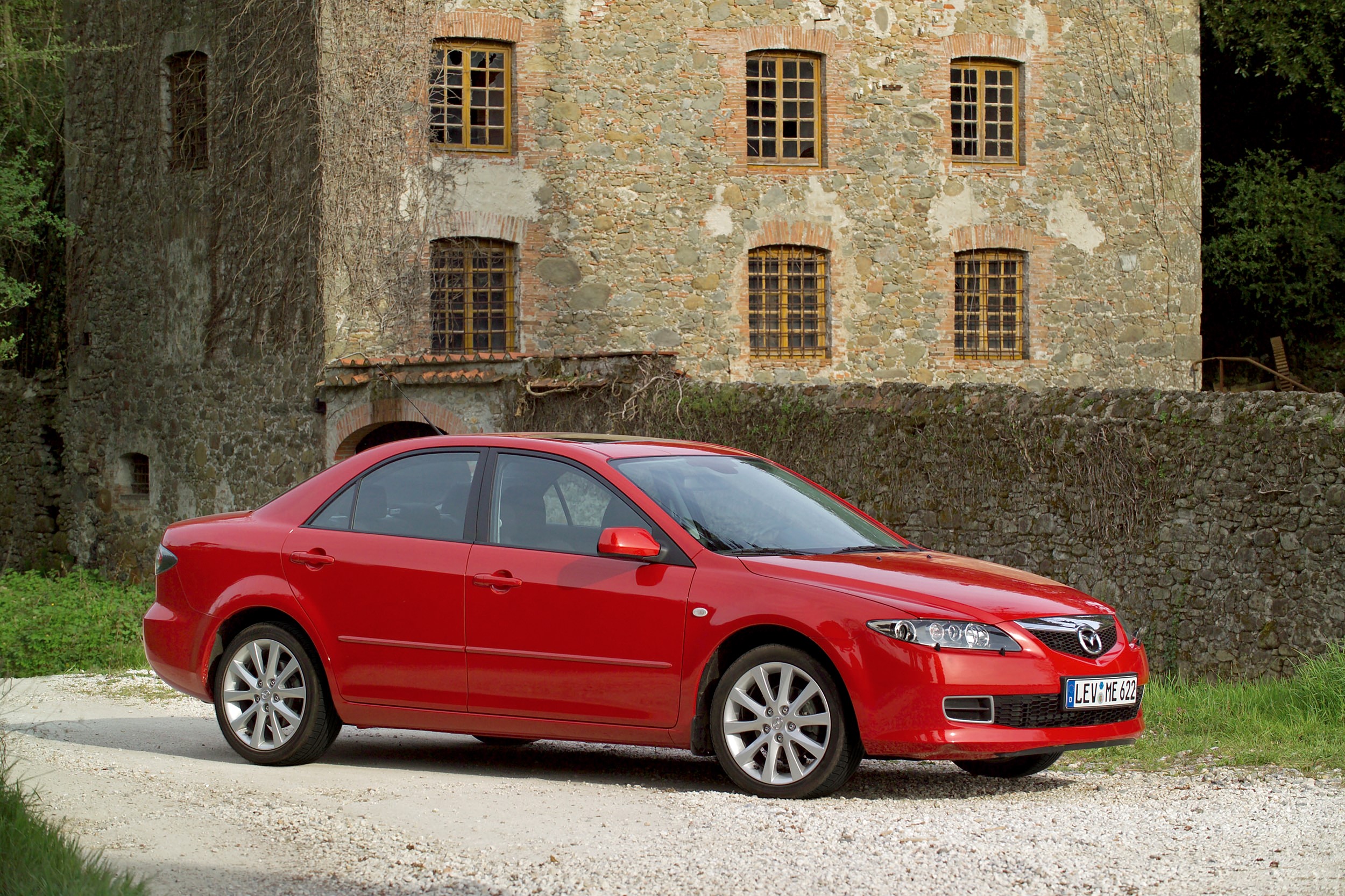 Red Mazda 6 Sedan parked near a stone building HD Wallpaper
