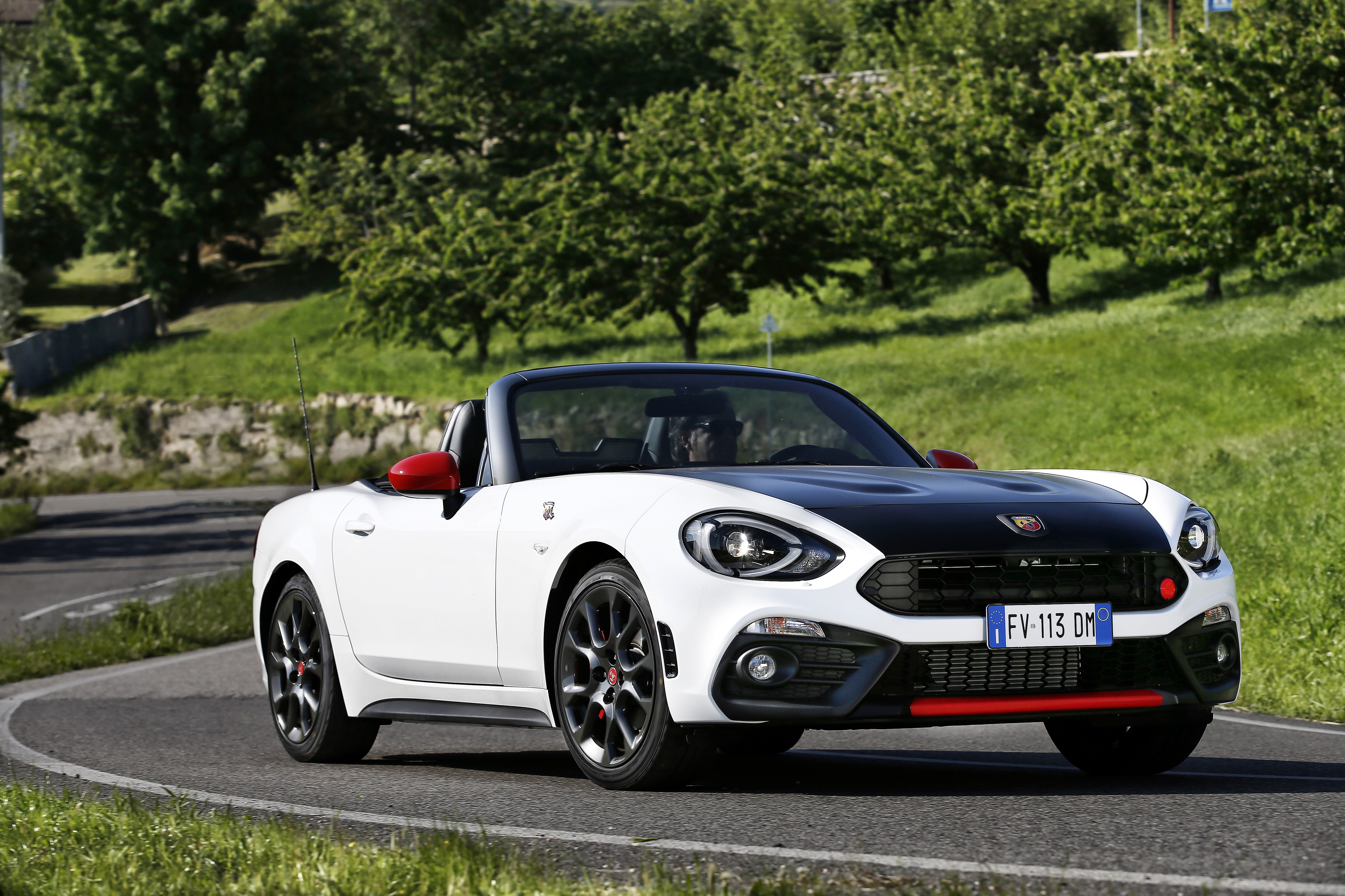White Abarth 124 Spider Cabriolet driving on a road HD Wallpaper