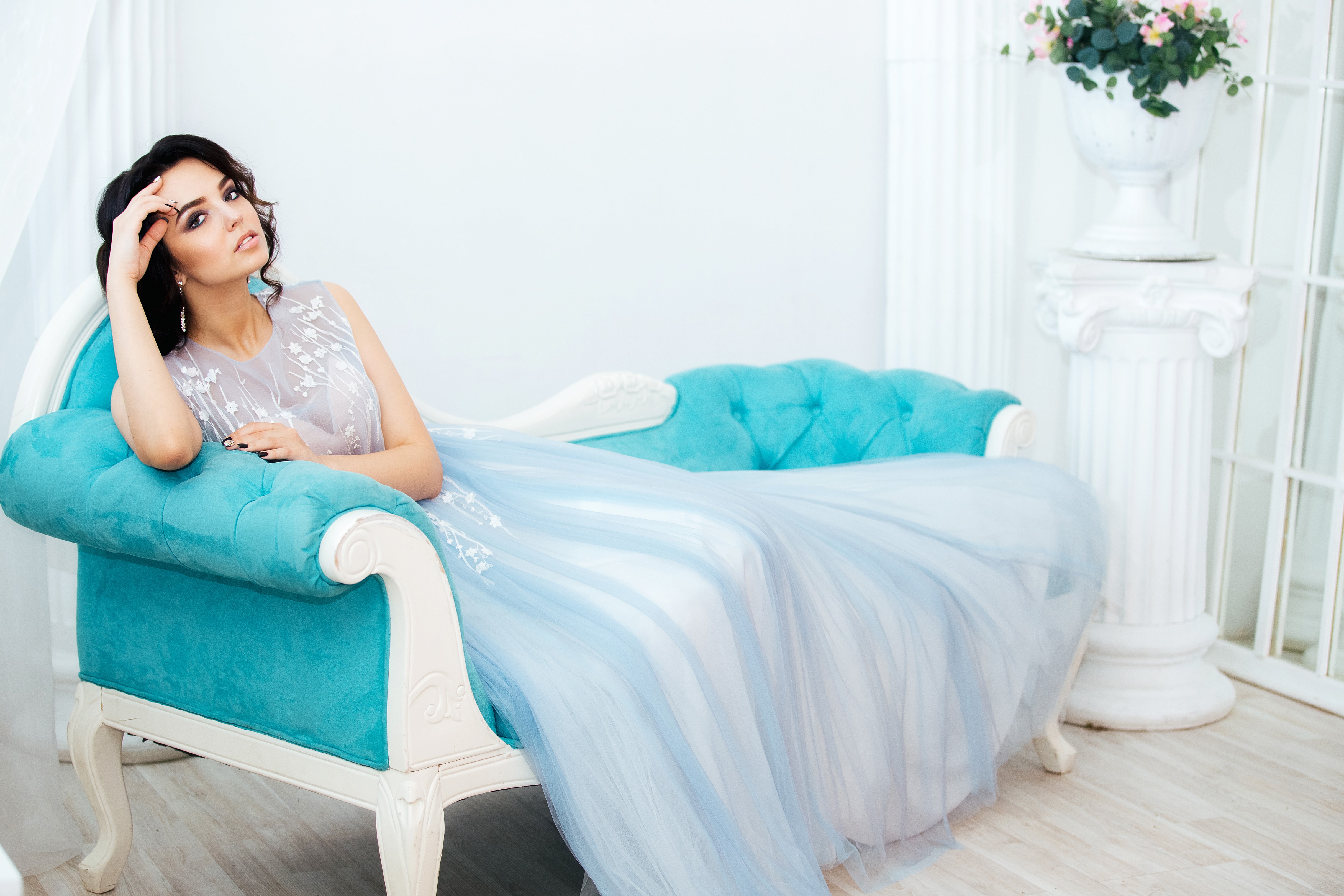 Brunette girl in a blue dress on a sofa HD Wallpaper