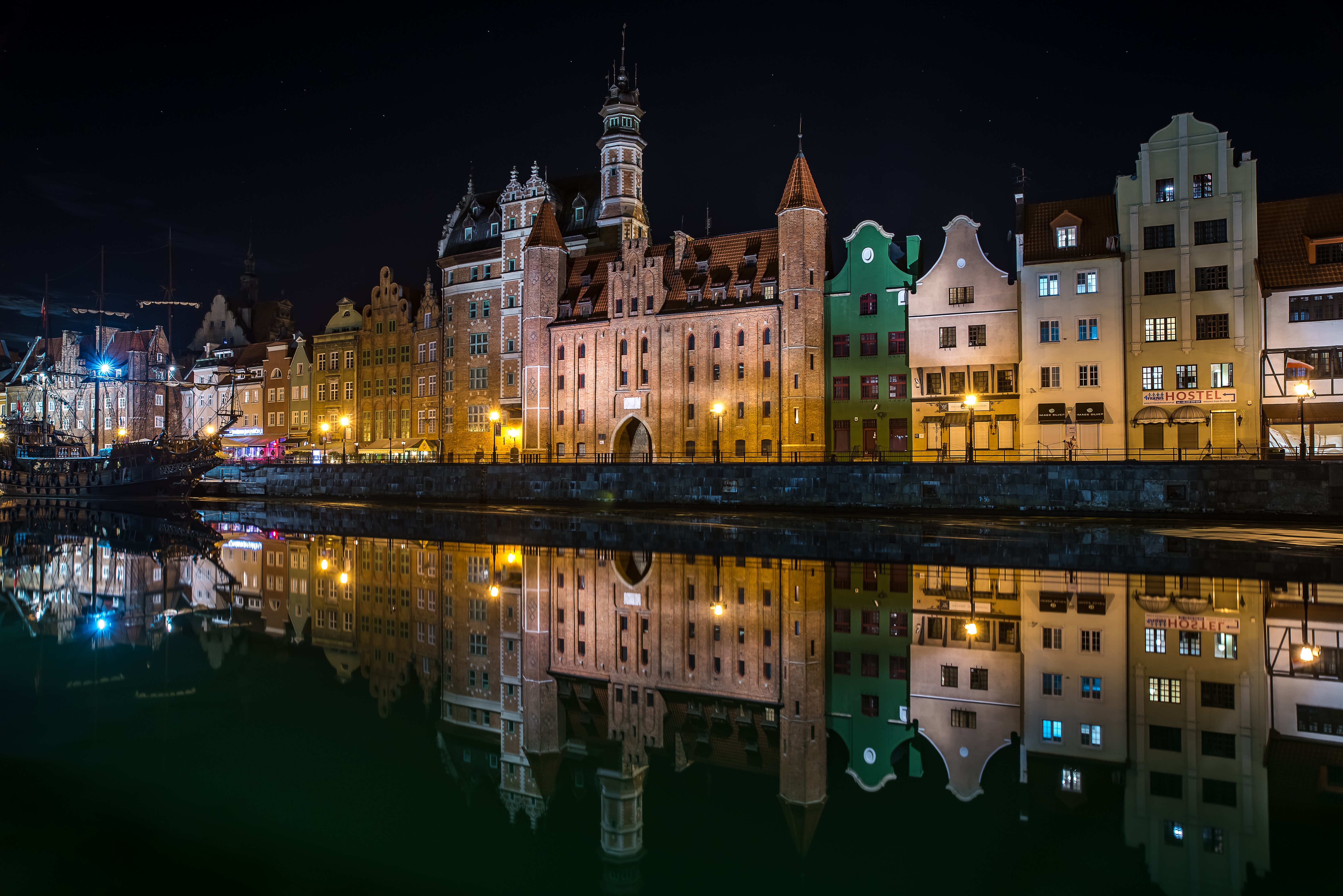 Gdańsk waterfront at night with reflections HD Wallpaper