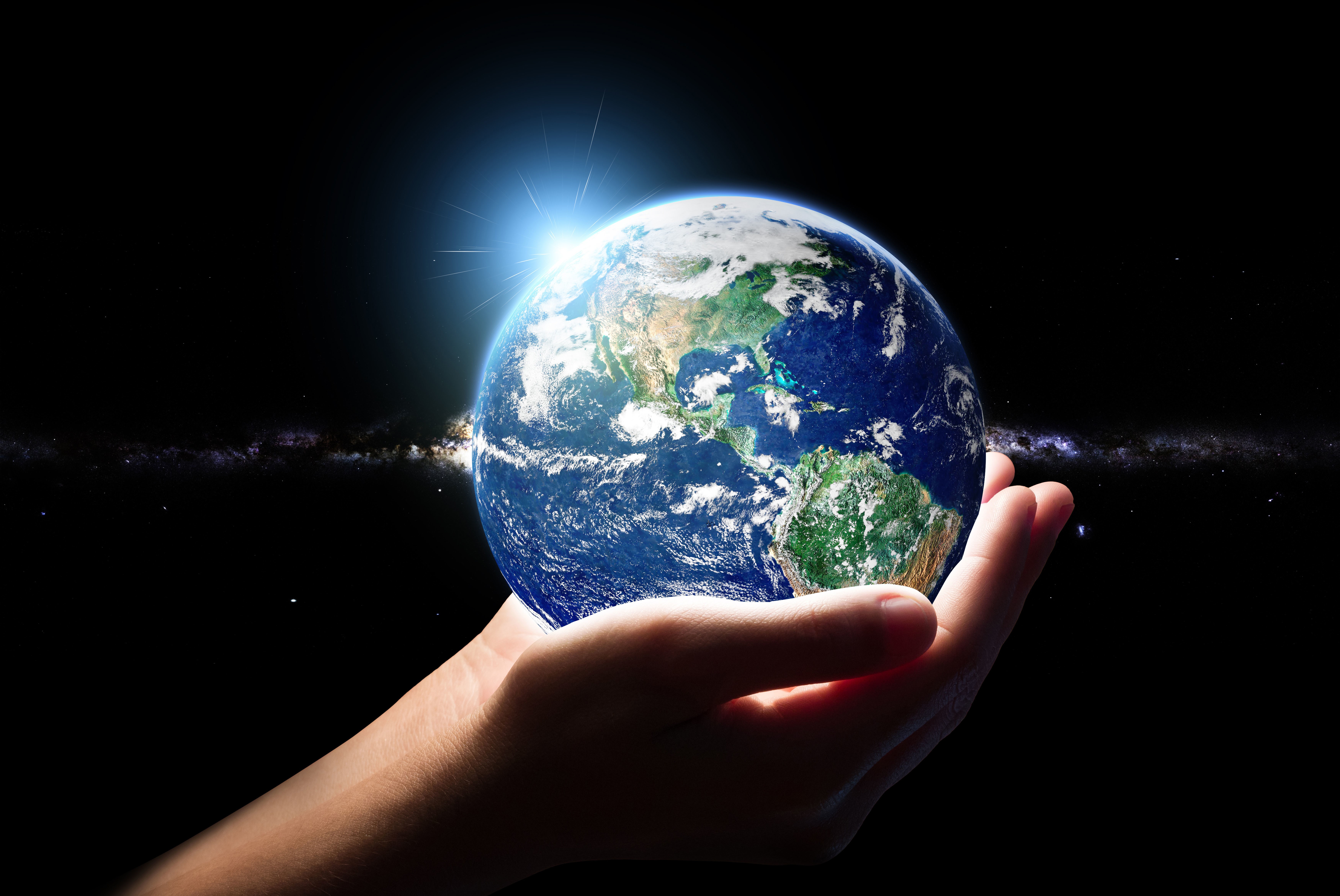 Hands holding planet Earth with sun flare and galaxy HD Wallpaper