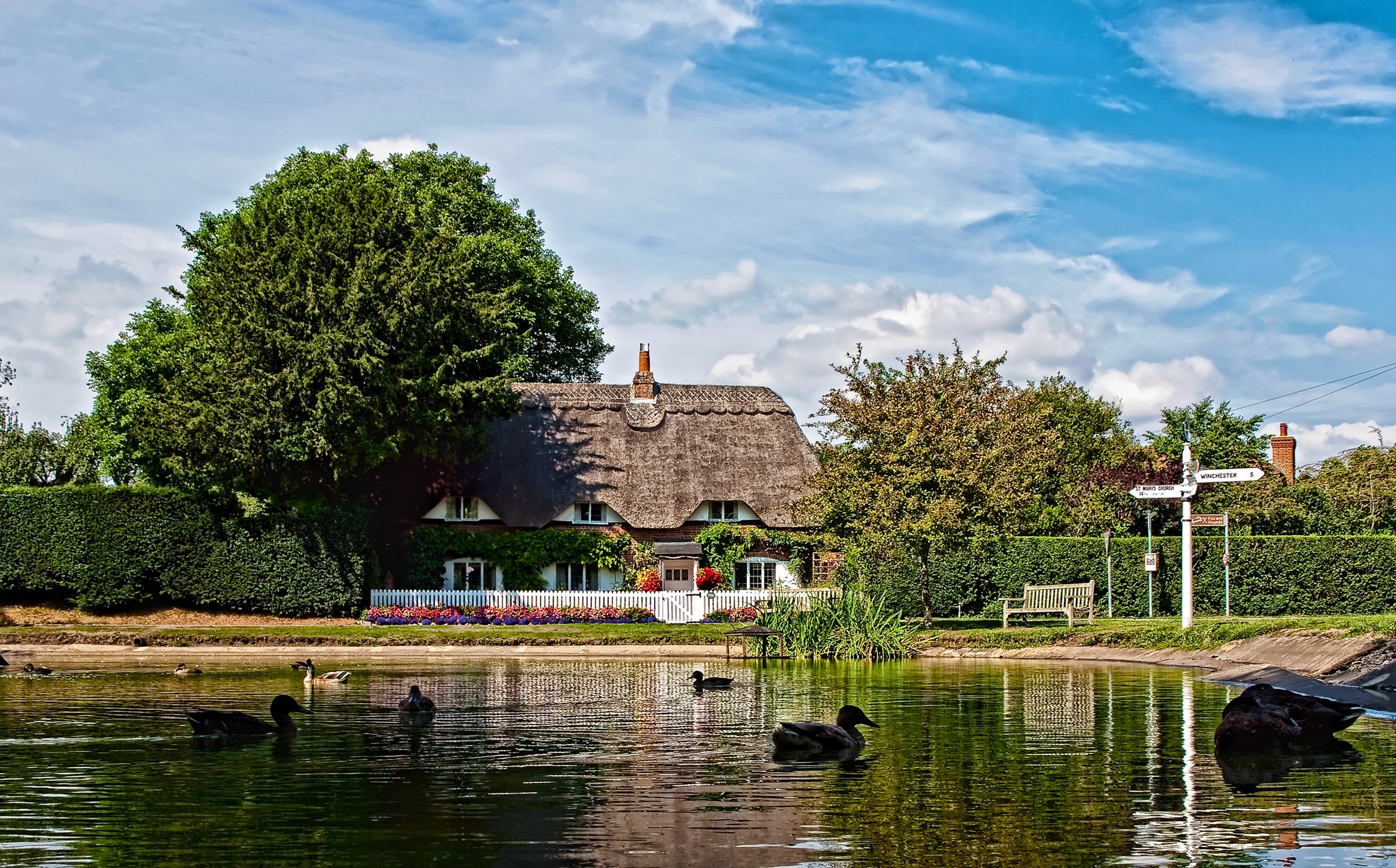 Thatched cottage by a pond with ducks in Crawley, Hampshire HD Wallpaper