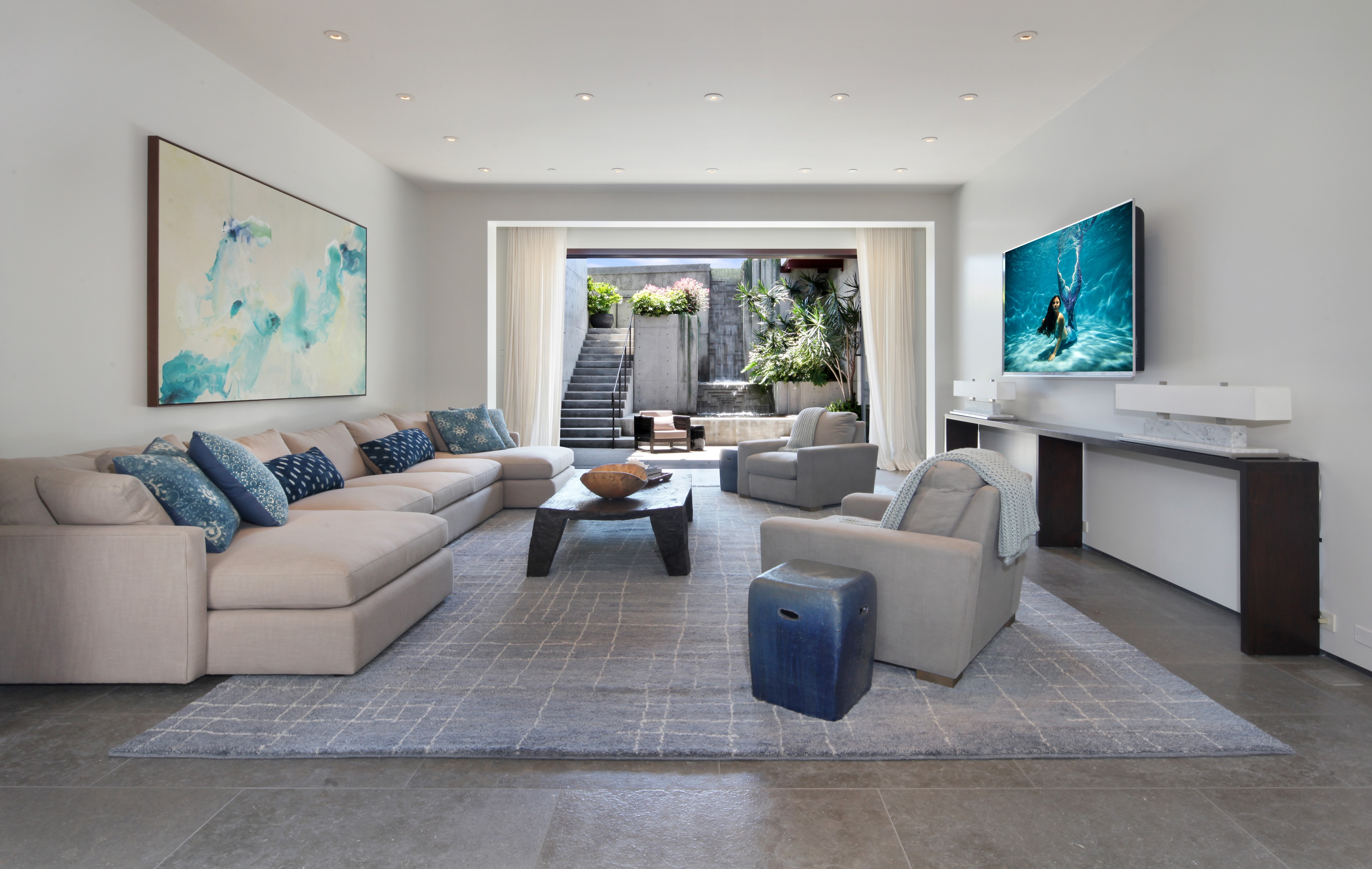Living room with sectional sofa, armchairs, and outdoor view HD Wallpaper