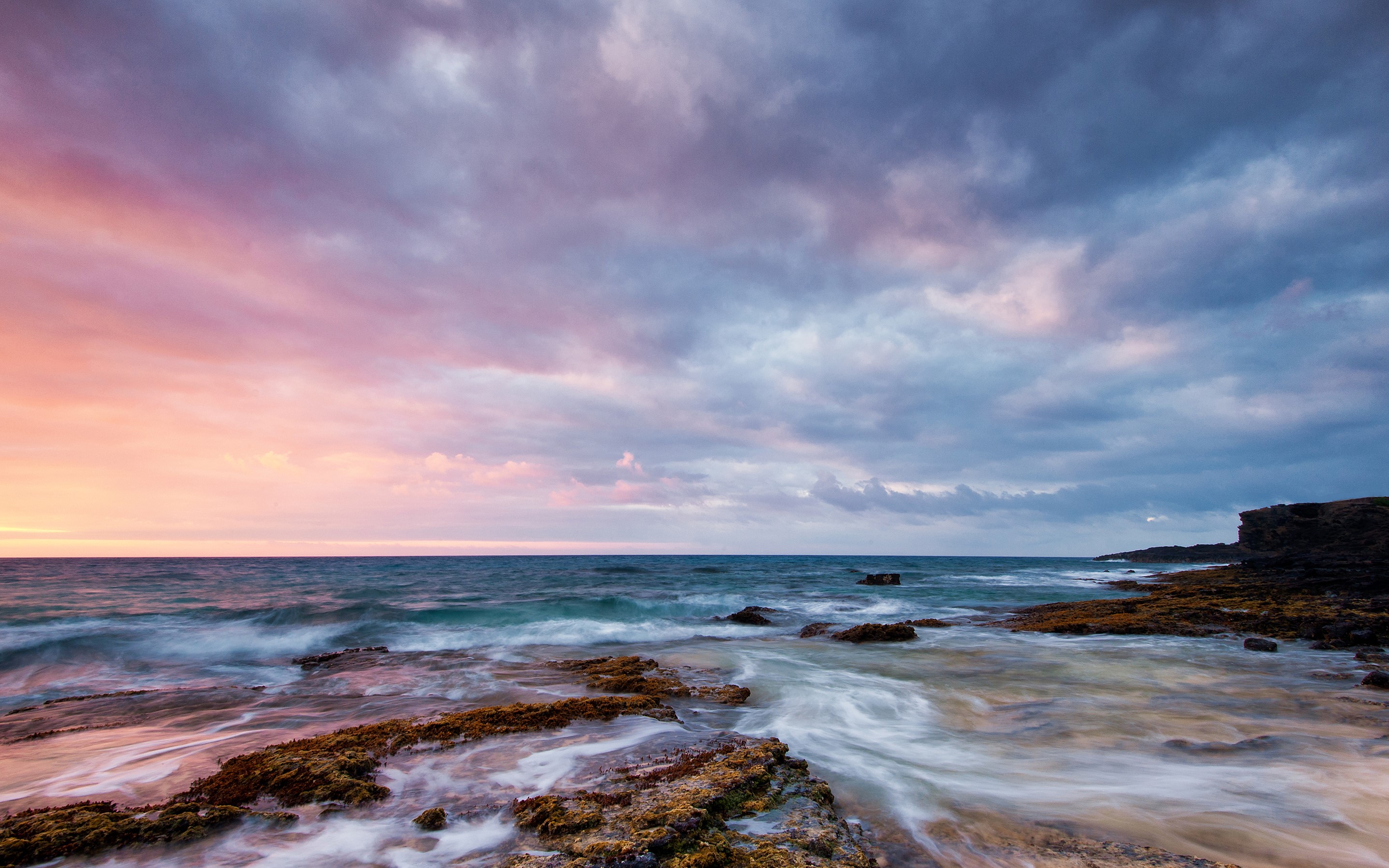 Ocean waves crashing on rocky shore at sunset HD Wallpaper