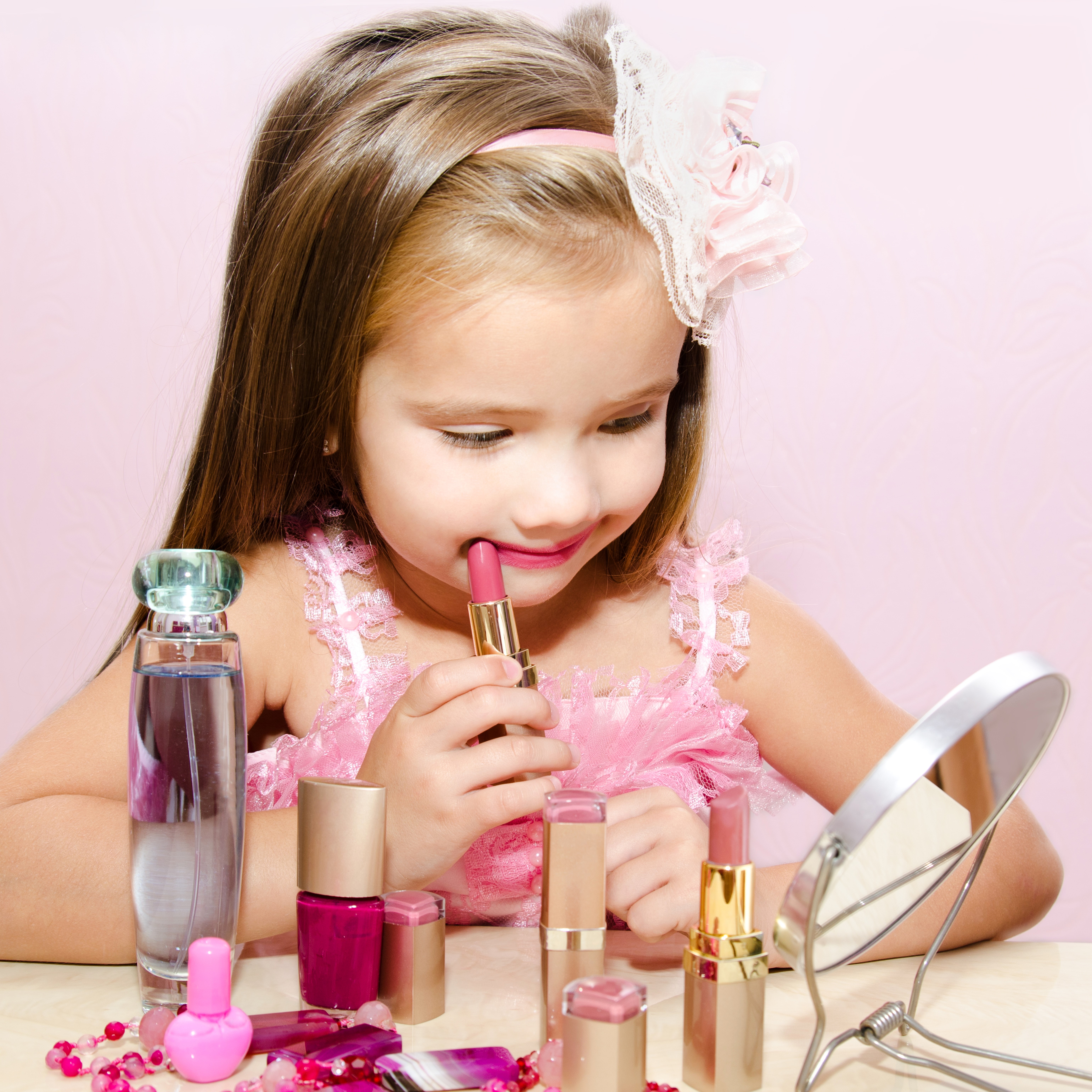 Little girl applying lipstick with makeup and perfume HD Wallpaper