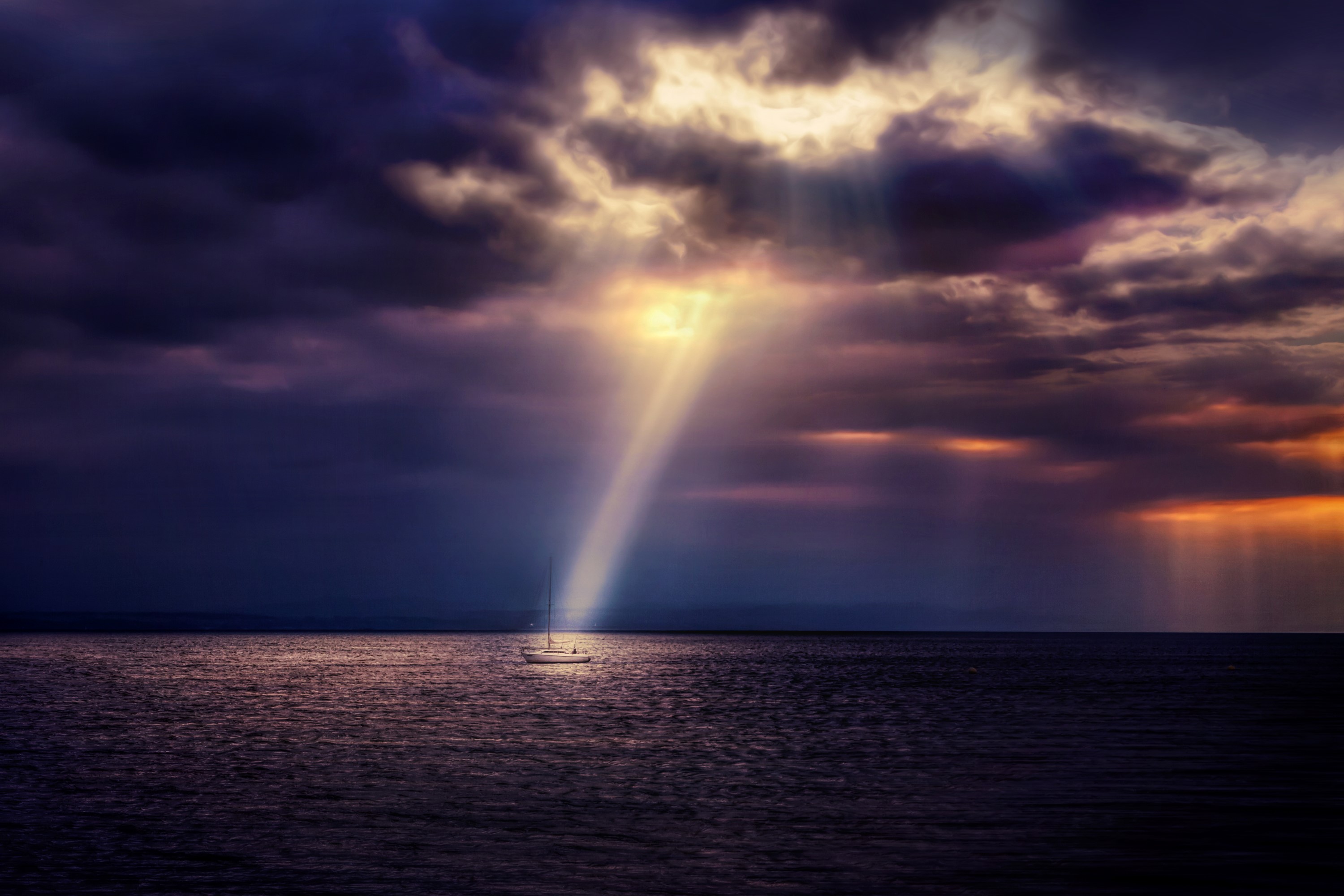 Sailboat in the sea under dramatic cloudy sky with sun rays HD Wallpaper