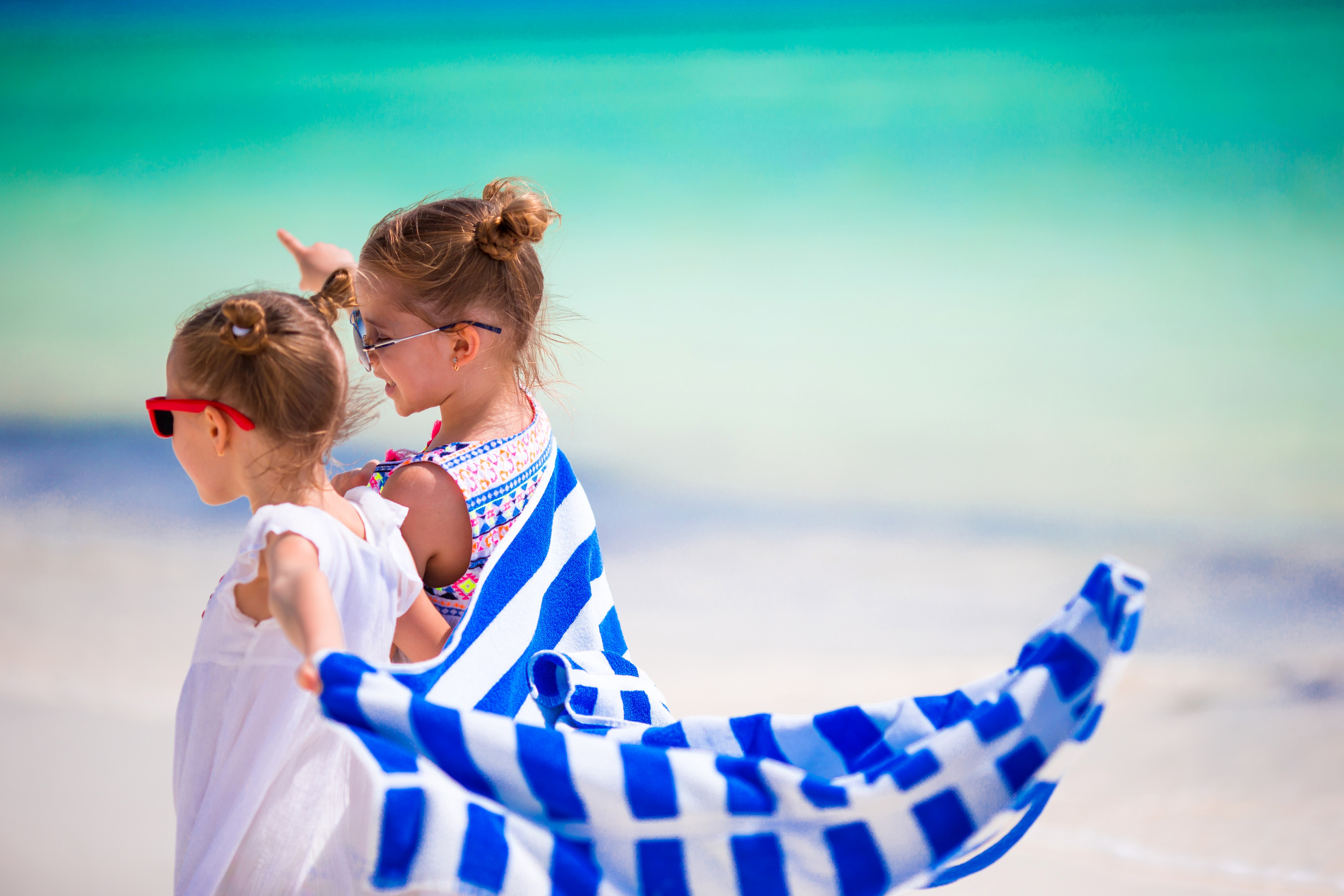 Two little girls on a beach with a towel HD Wallpaper