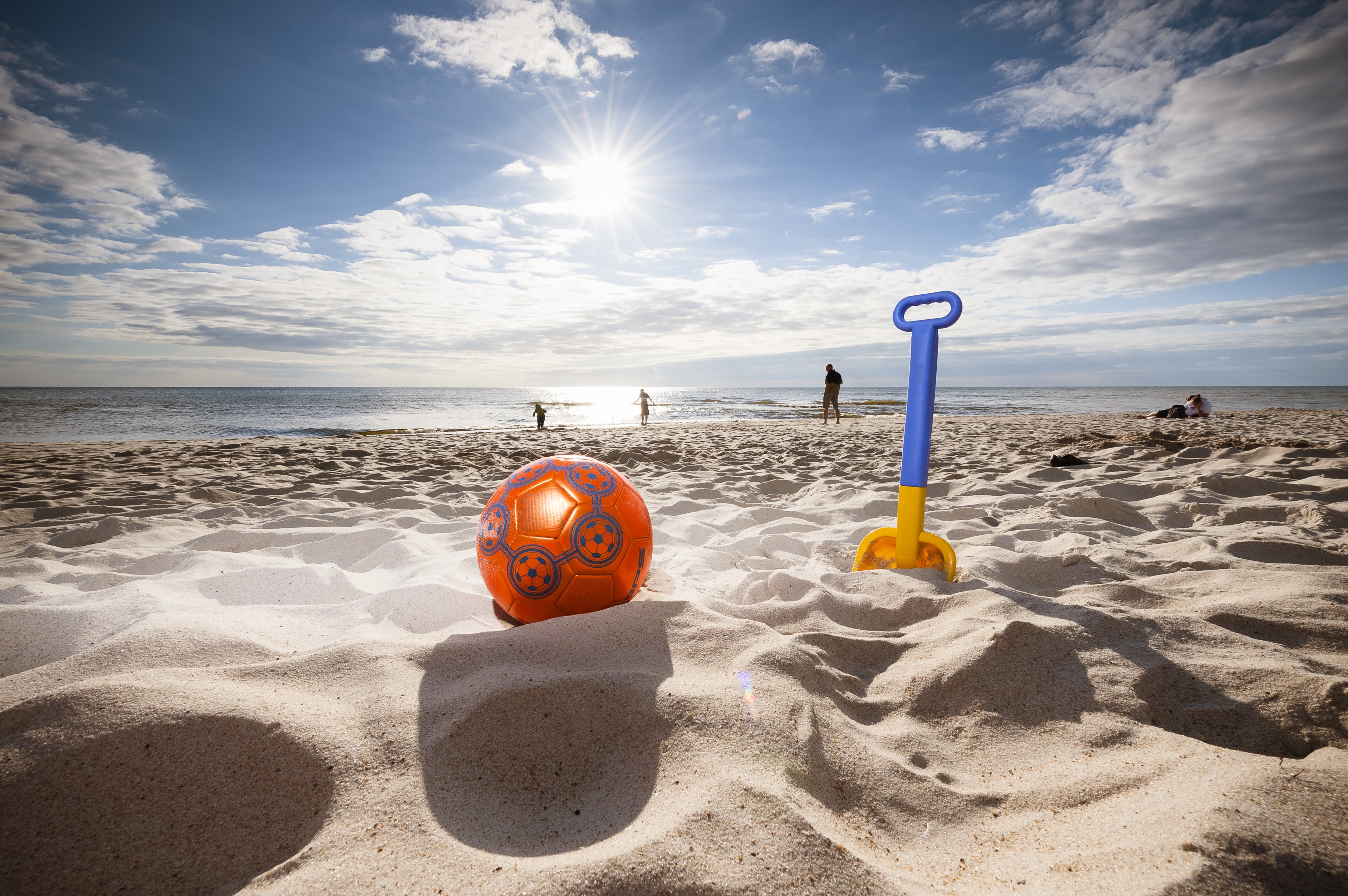 Beach with ball and shovel on a sunny day HD Wallpaper