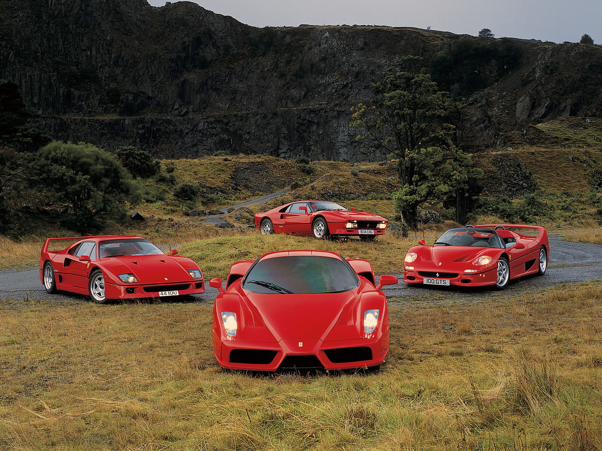 Four red Ferraris in a rocky landscape HD Wallpaper