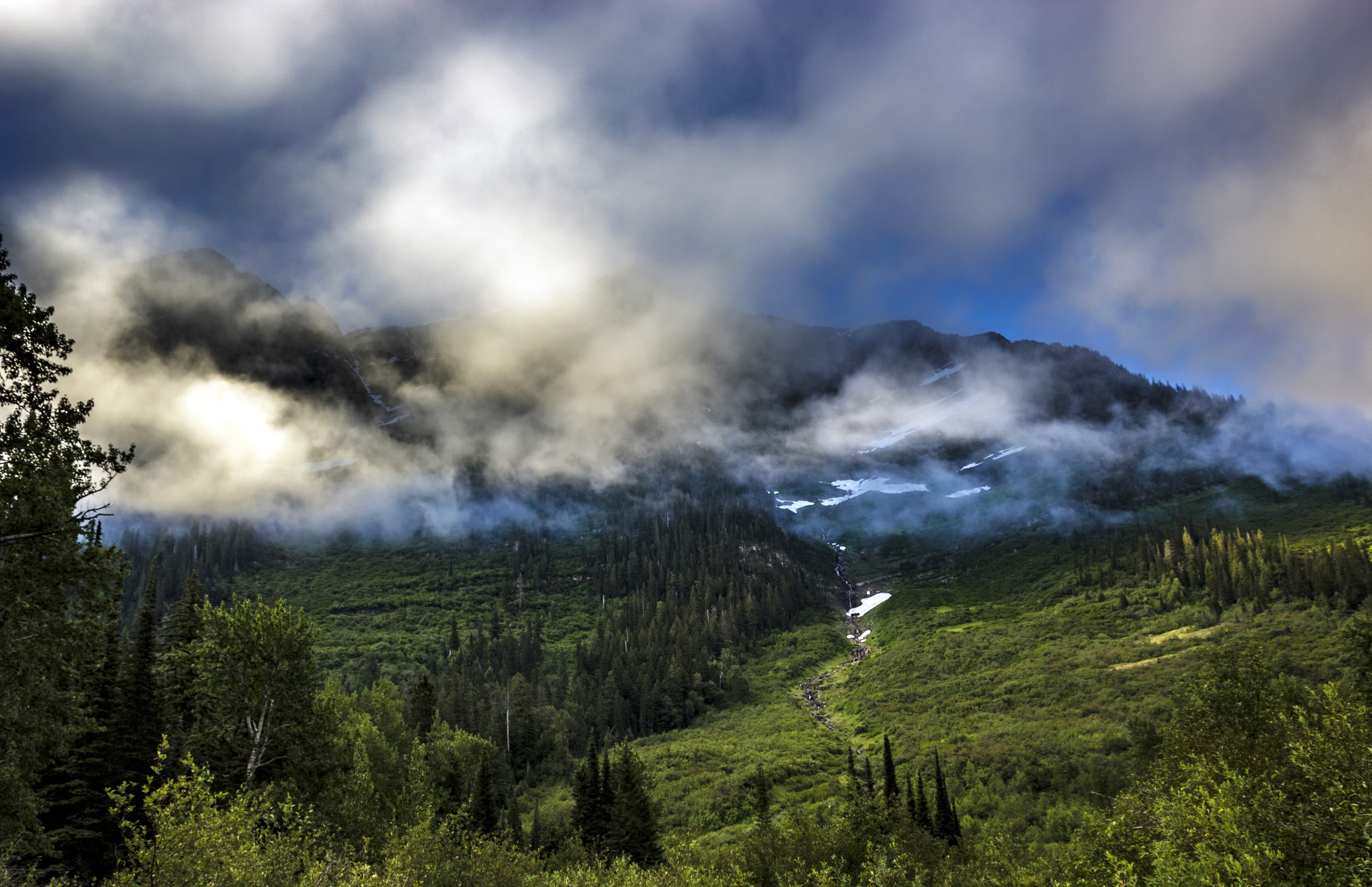 Mountains shrouded in fog in Glacier National Park, Montana HD Wallpaper