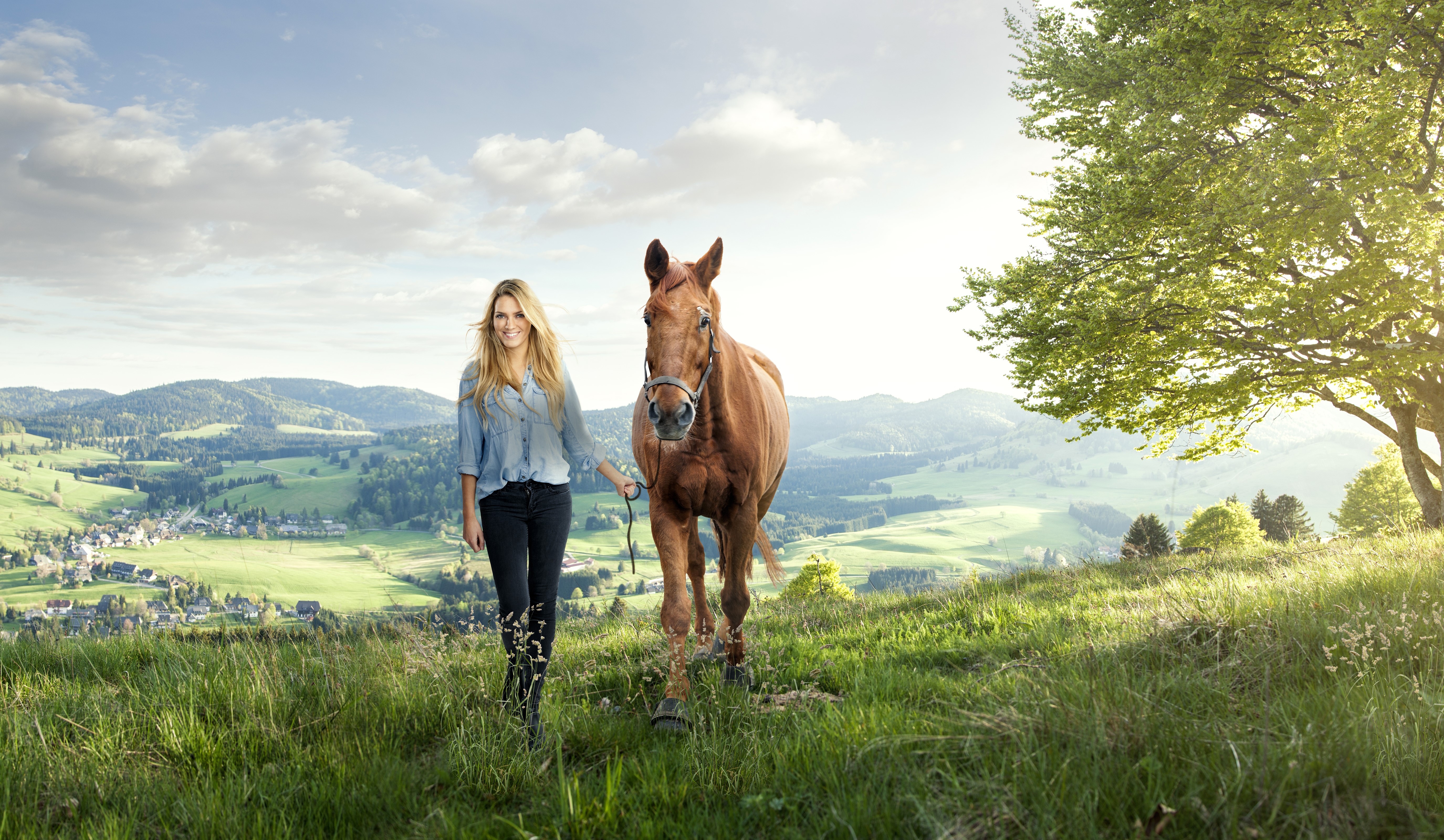 Woman walking a horse in a grassy landscape HD Wallpaper