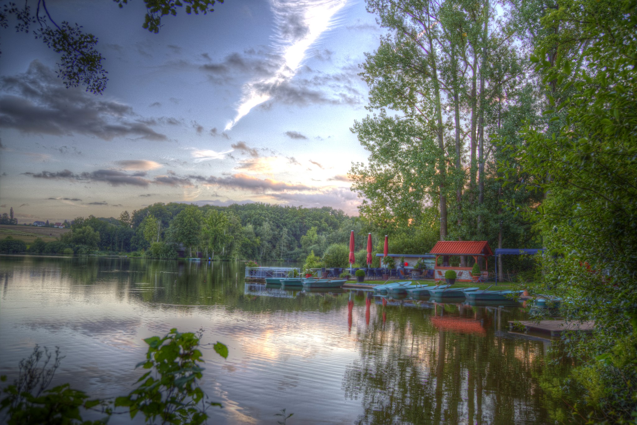 Boats docked at a lake marina with trees and sky HD Wallpaper