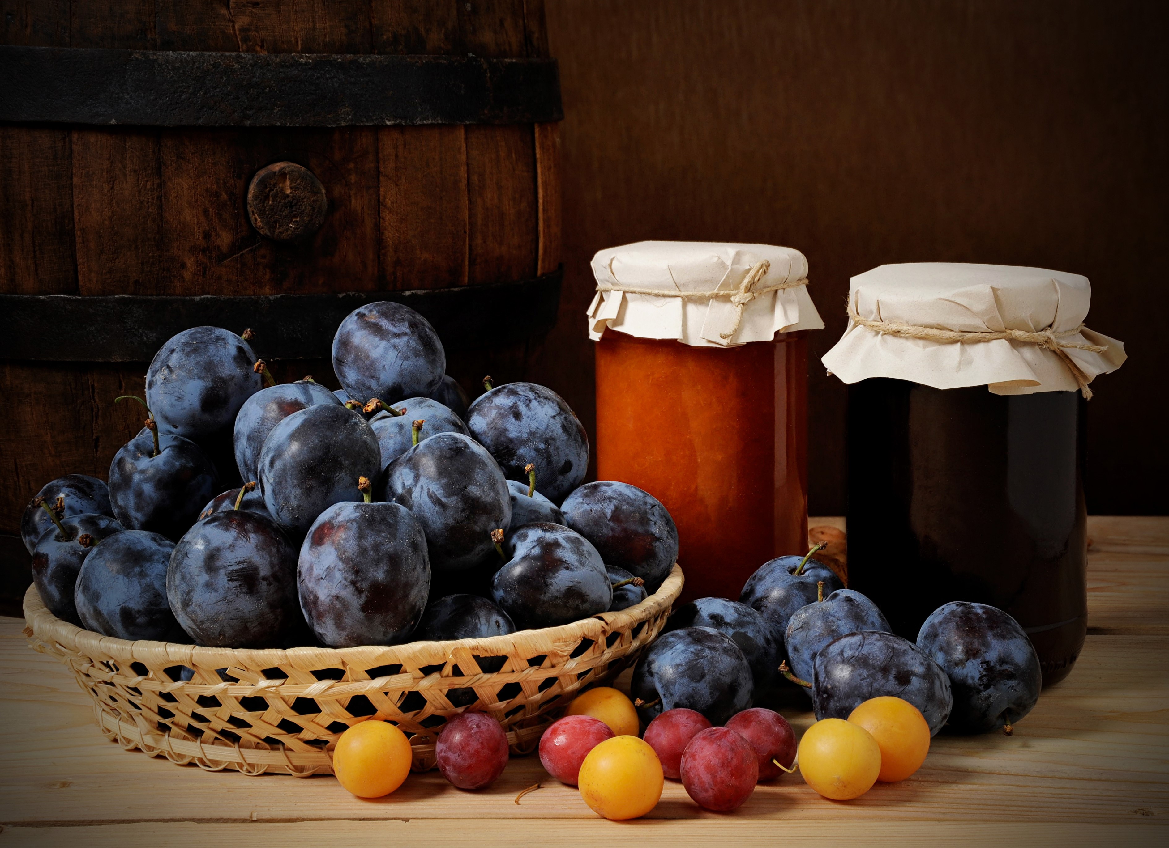 Plums and jam jars next to a wooden barrel HD Wallpaper