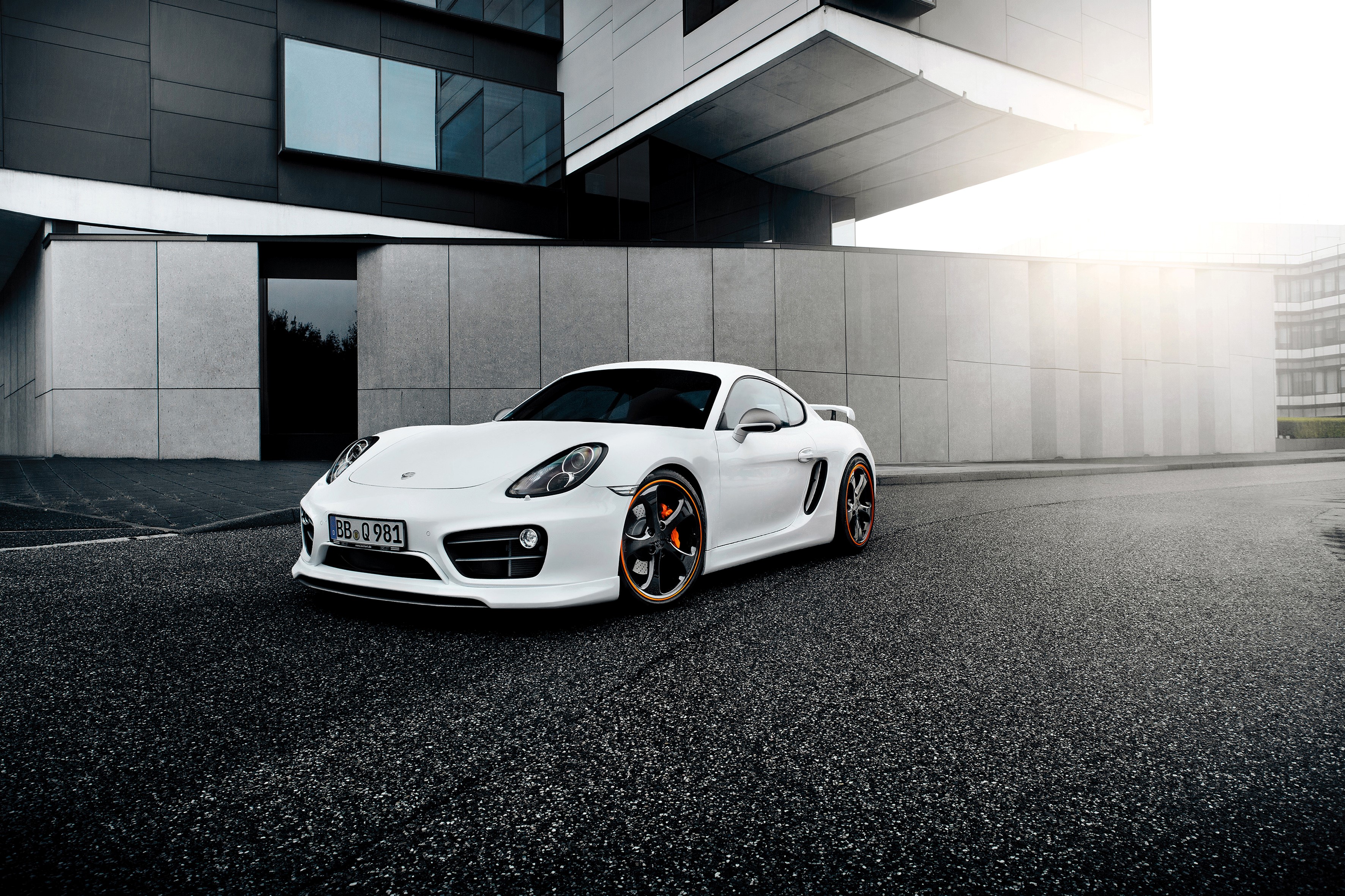 White TechArt Porsche Cayman S (981C) parked outside modern building HD Wallpaper