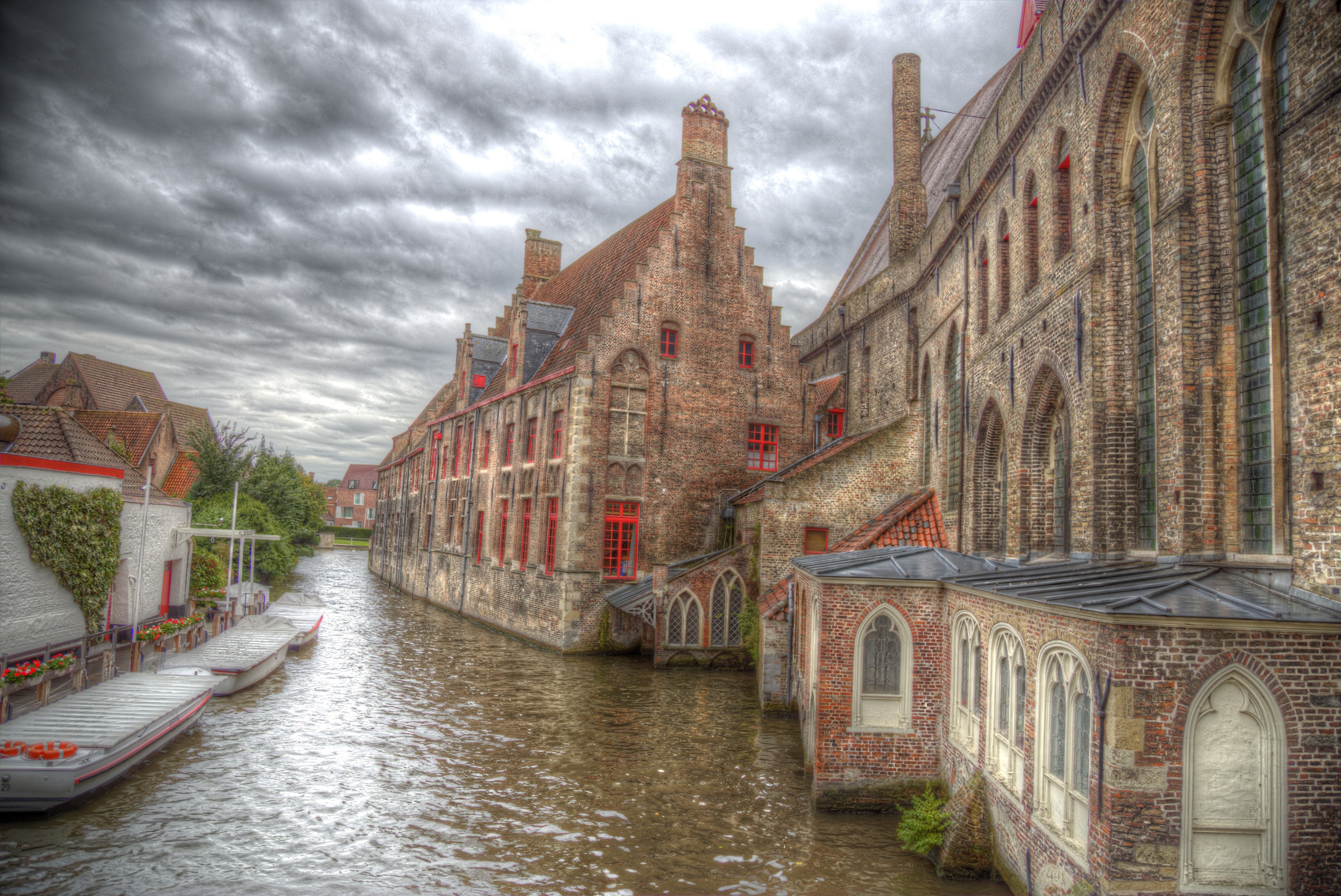 Canal in Bruges, Belgium with historic buildings and boats HD Wallpaper
