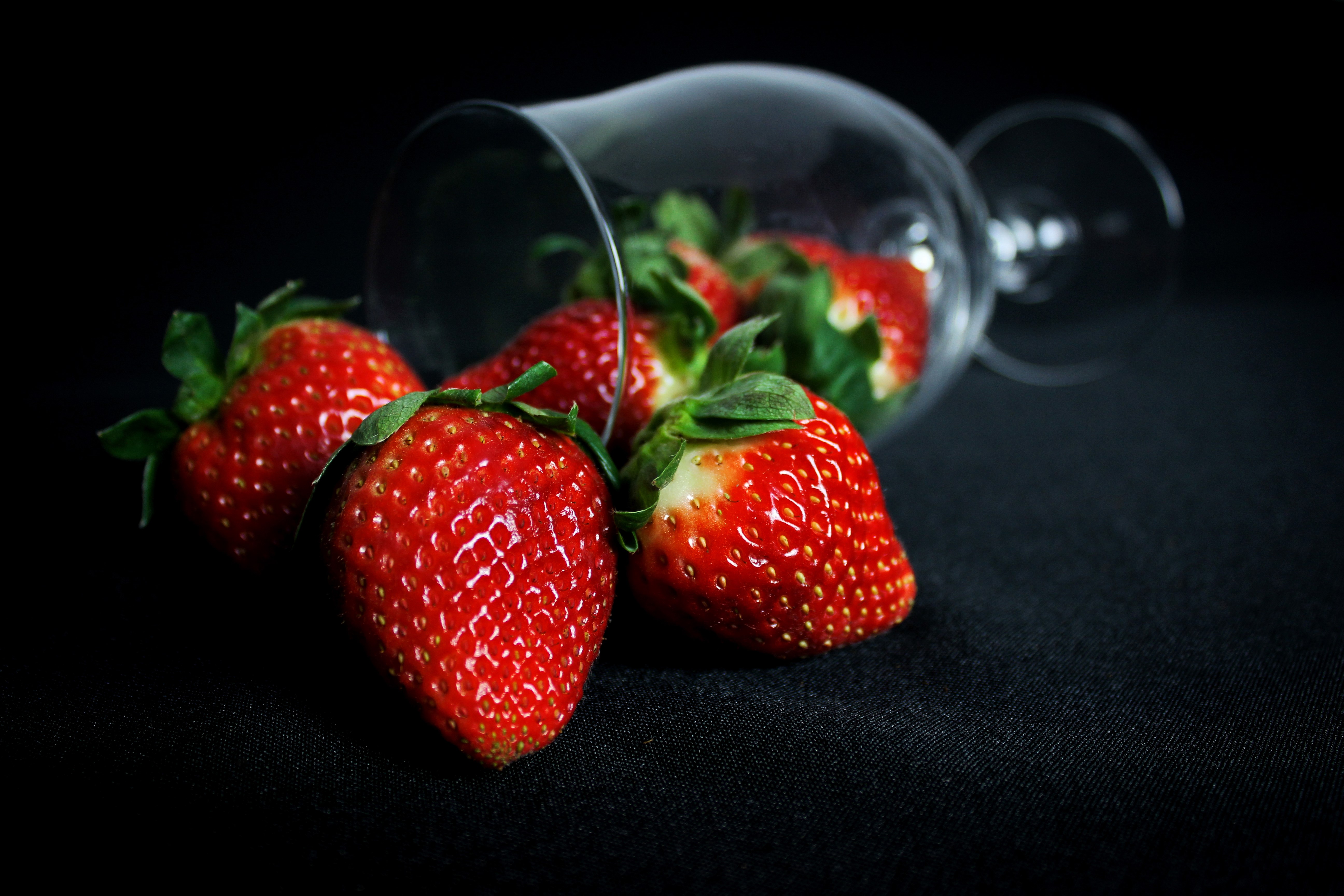 Strawberries spilling from a shot glass HD Wallpaper
