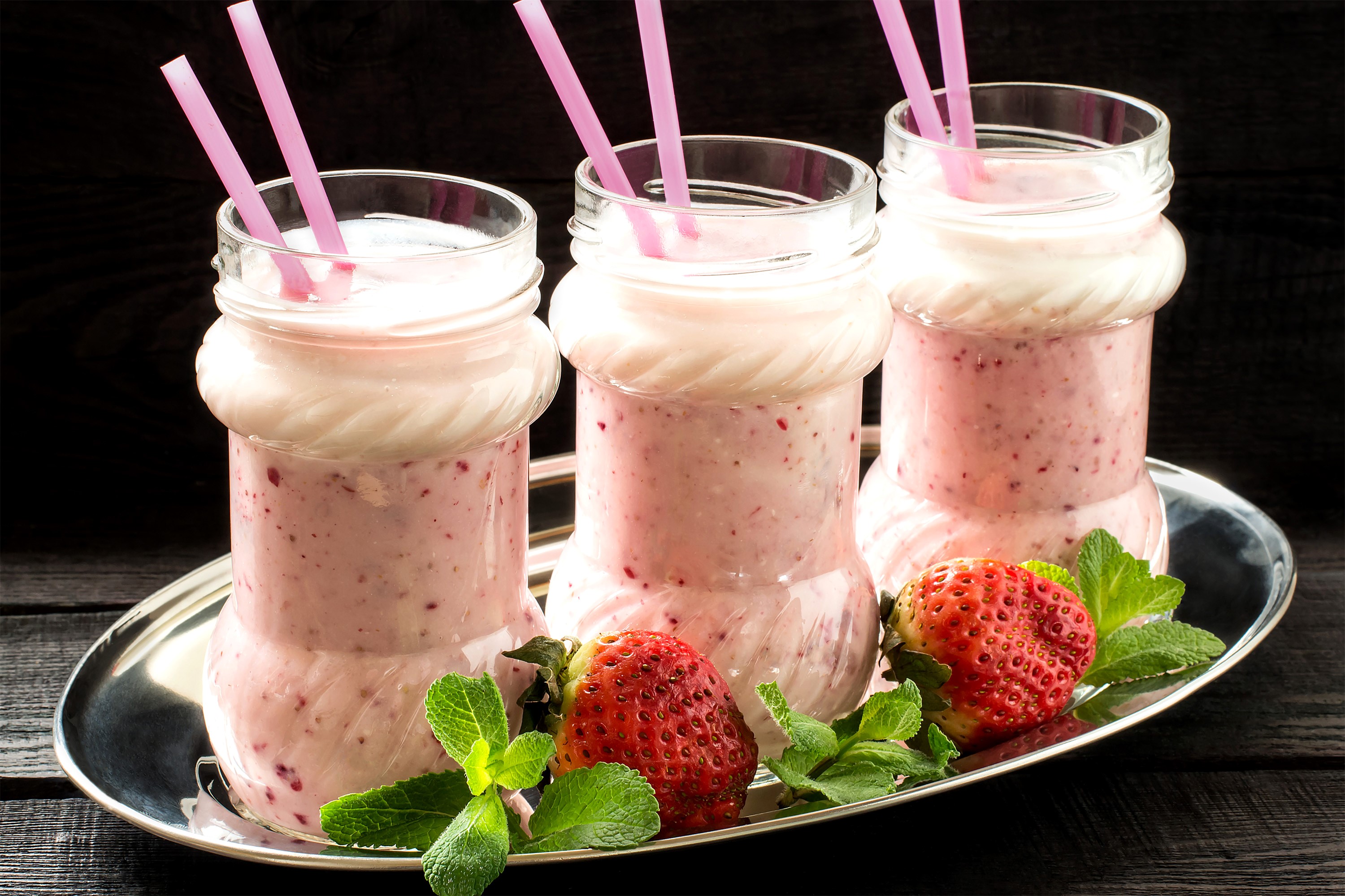 Three strawberry milkshakes with pink straws on a tray HD Wallpaper