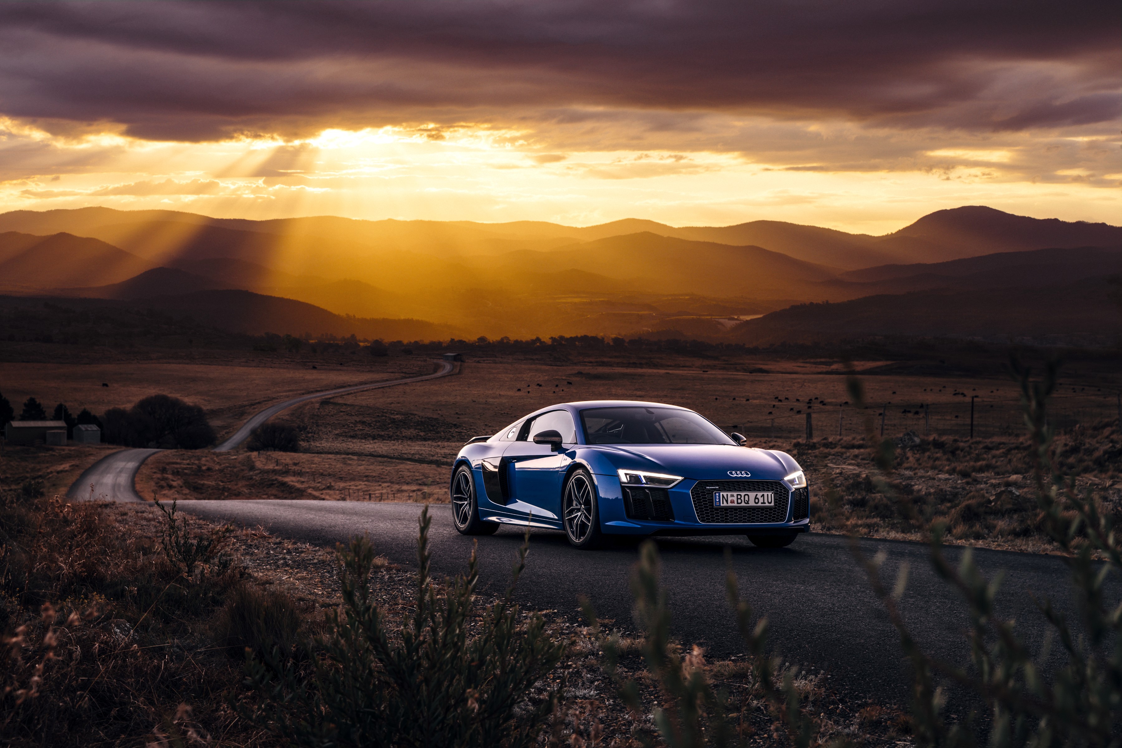 Blue Audi R8 V10 Plus on a winding road at sunset HD Wallpaper