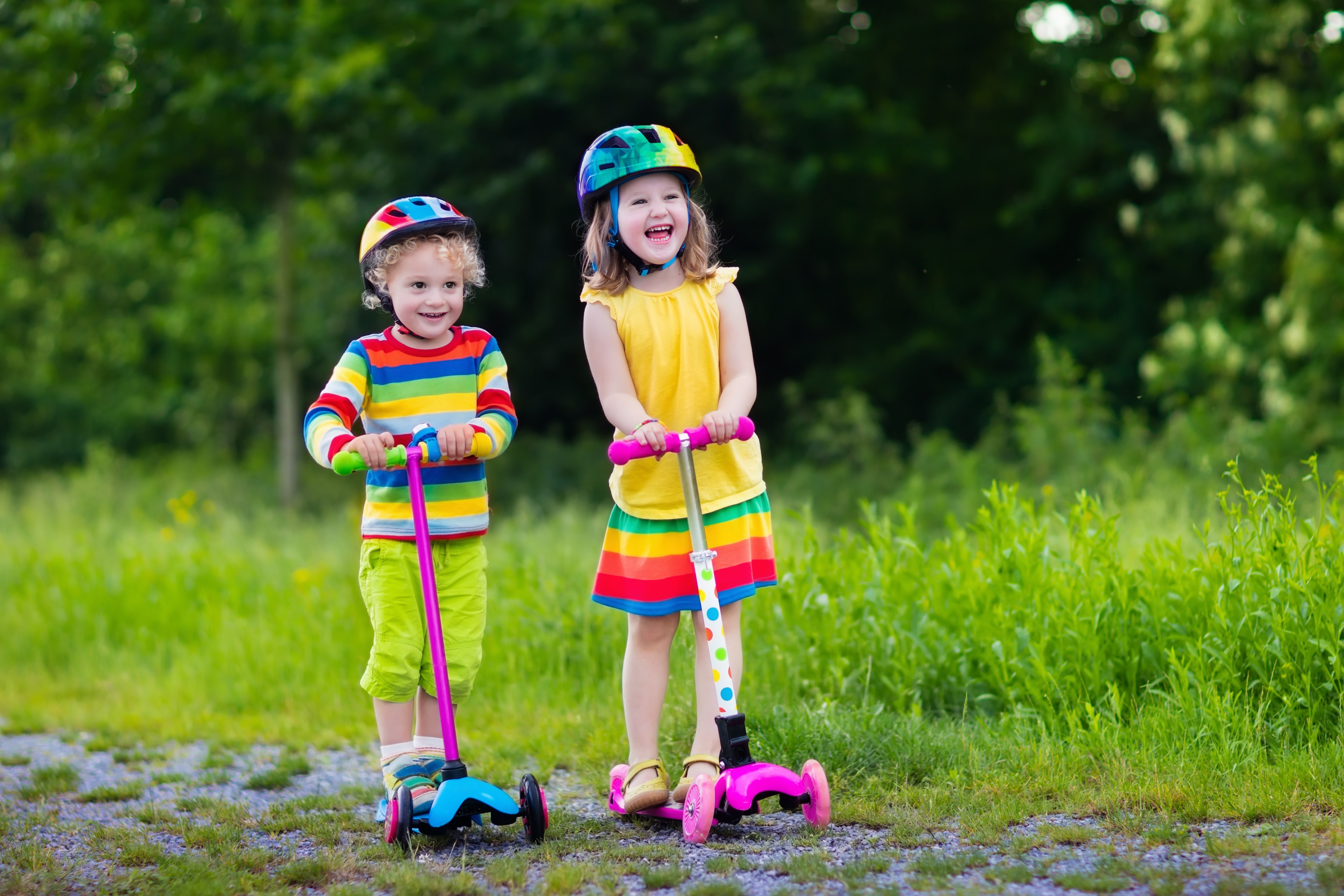 Two Children on Scooters Wearing Helmets HD Wallpaper
