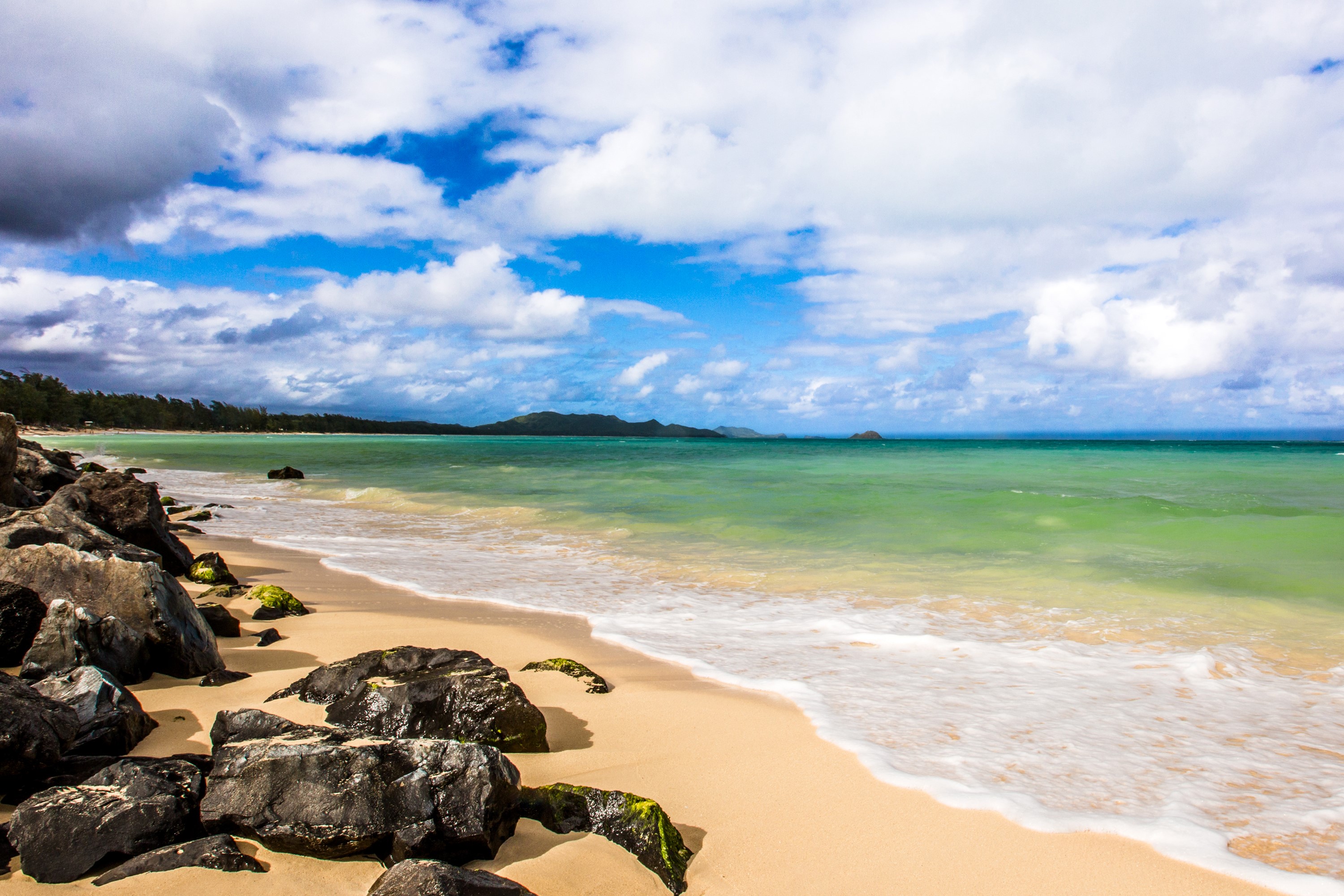 Beach with rocks, ocean, and clouds in Hawaii HD Wallpaper