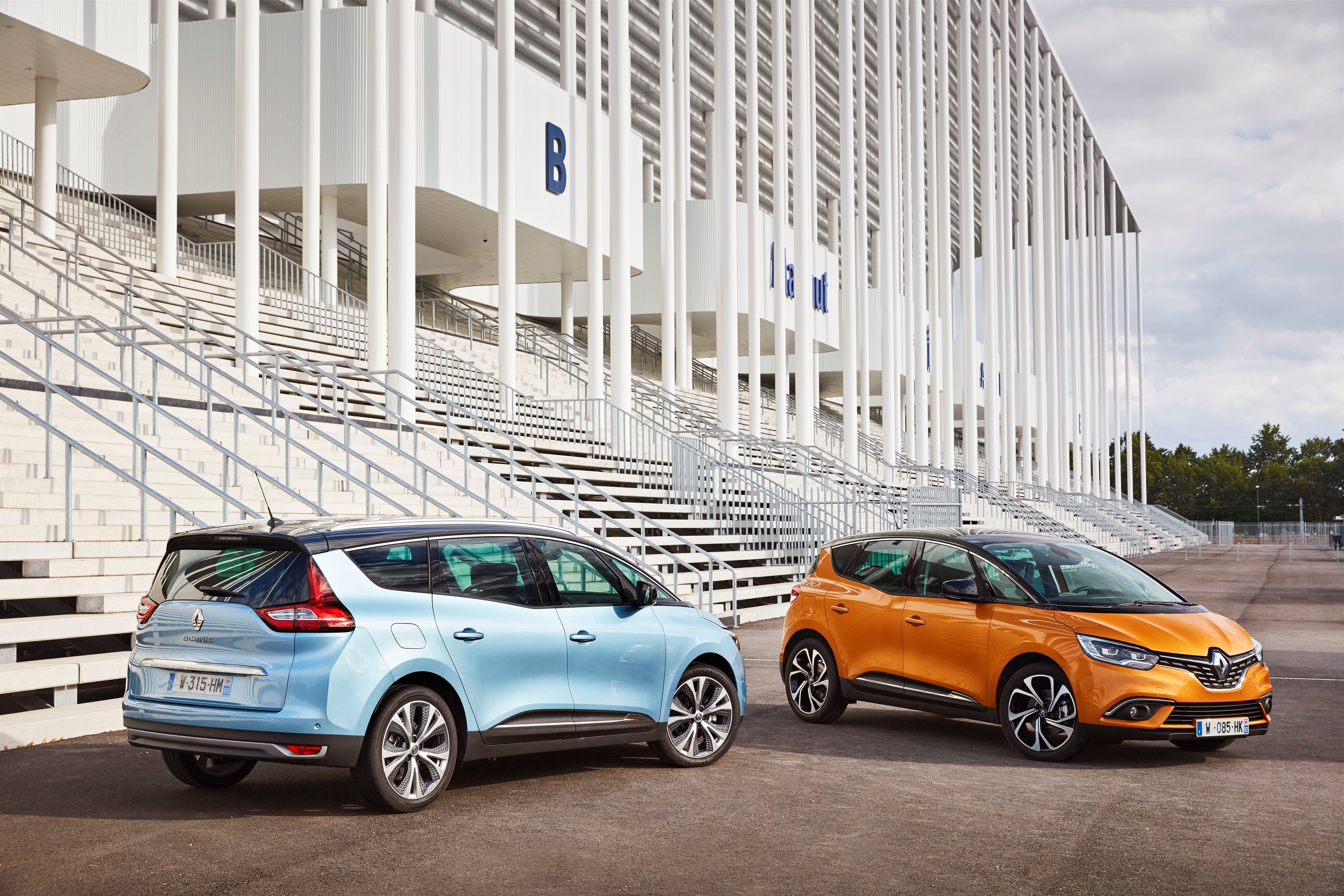 Two Renault Scenic cars in front of stadium stands HD Wallpaper