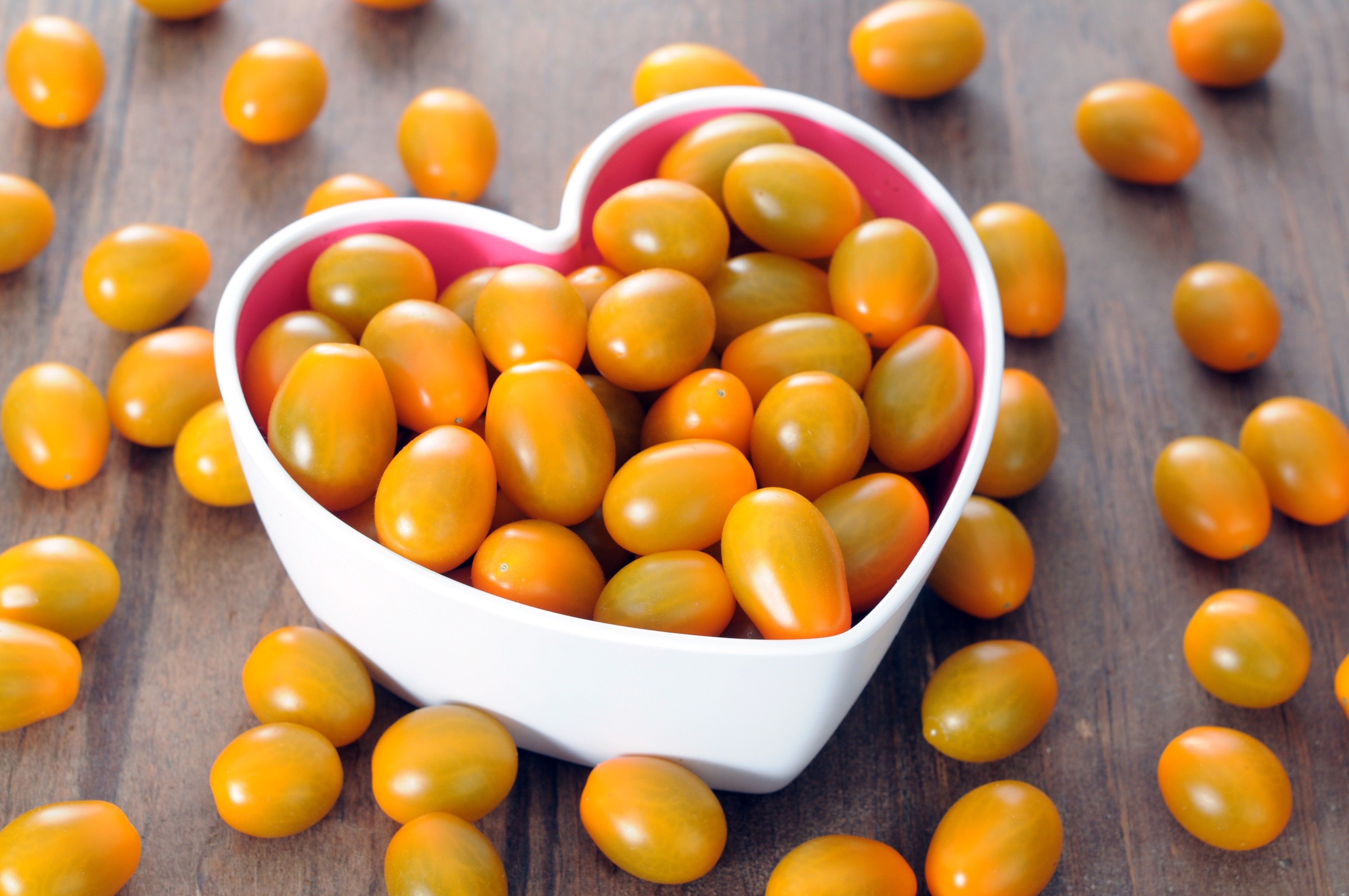 Yellow cherry tomatoes in a heart-shaped bowl HD Wallpaper