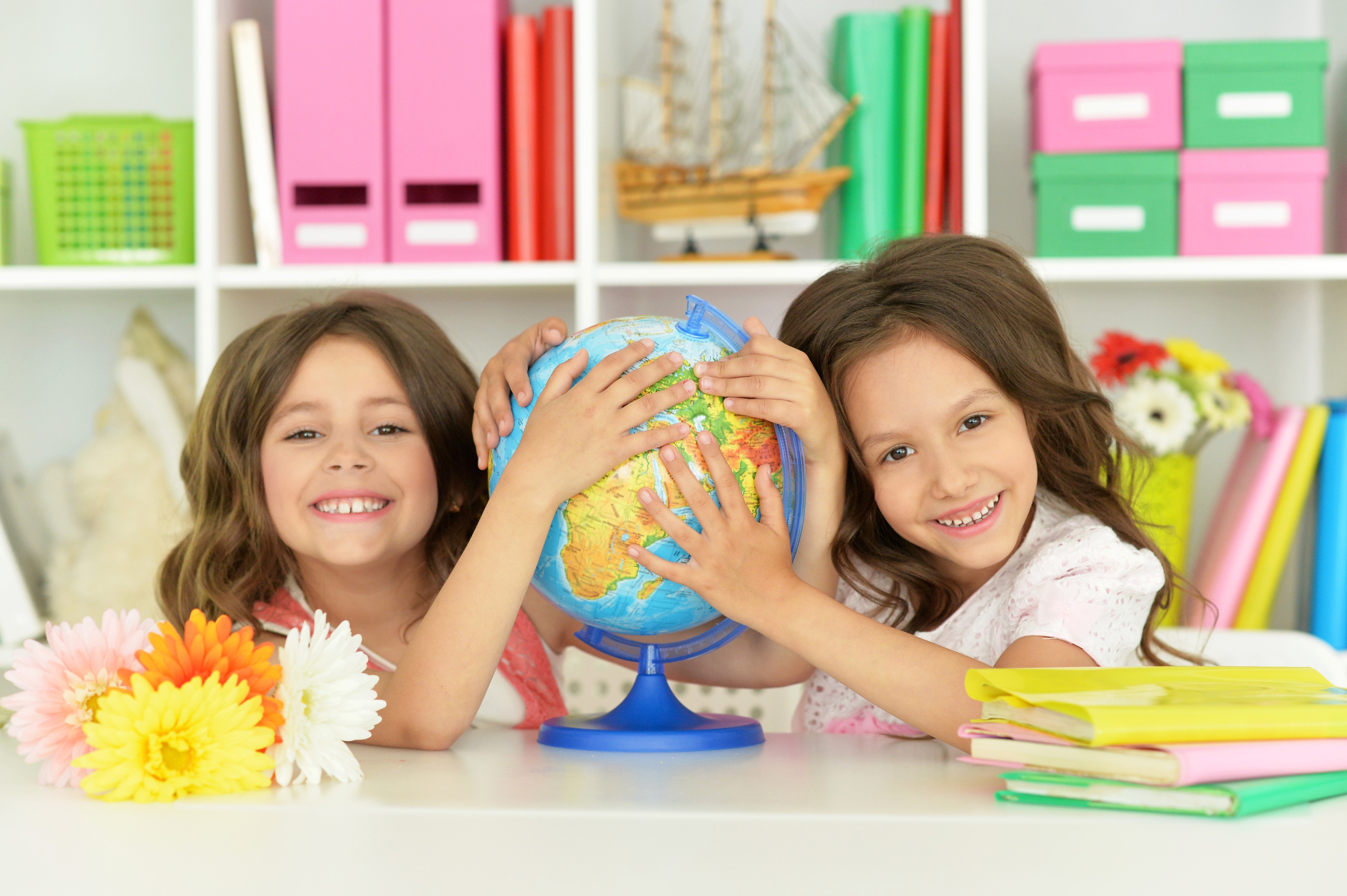 Two little girls holding a globe HD Wallpaper