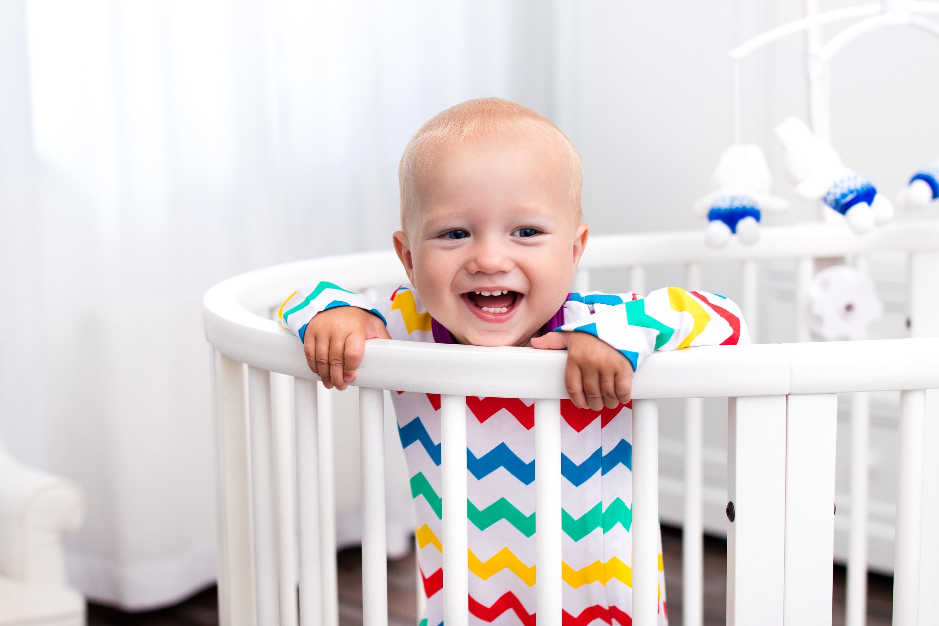 Baby smiling in a crib HD Wallpaper