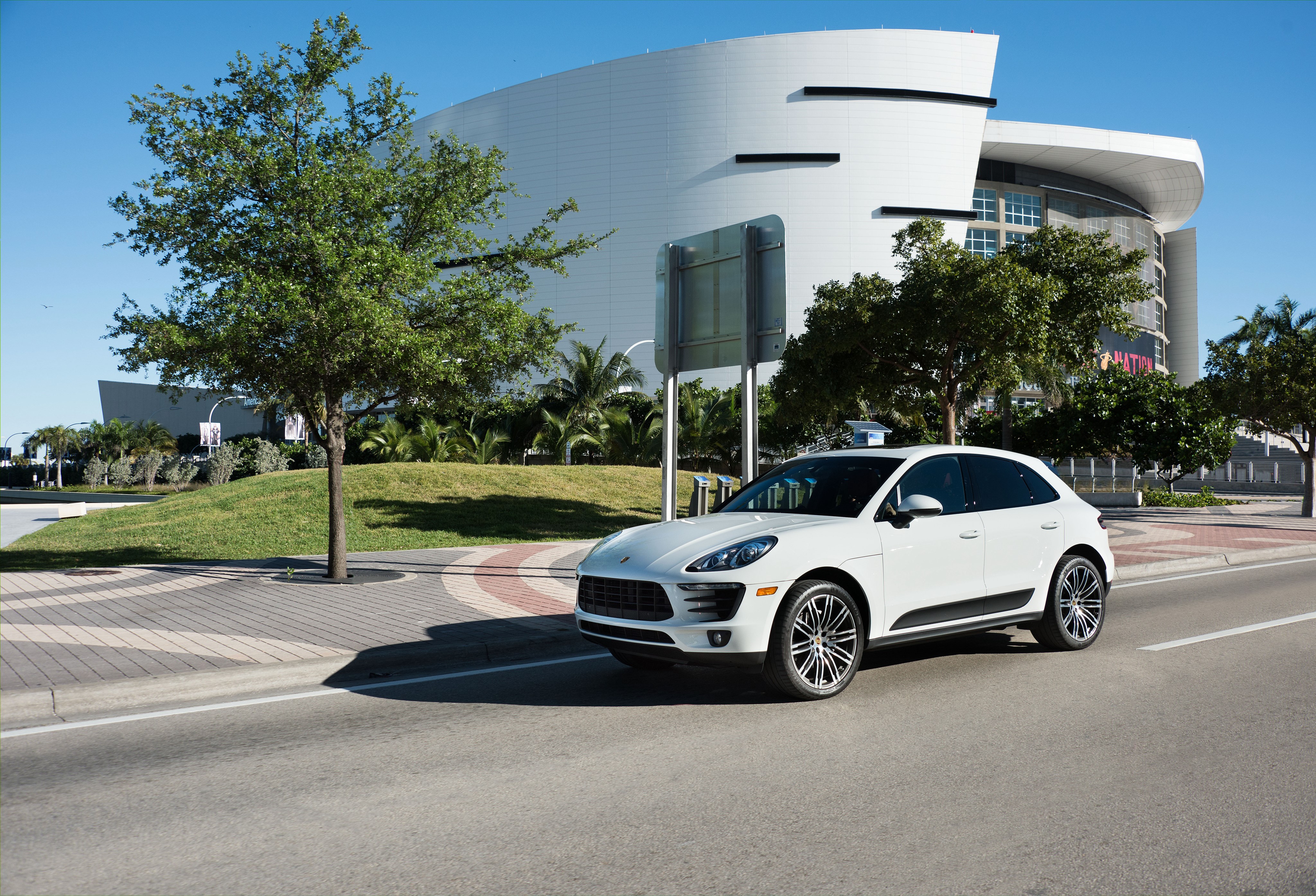 2015 Porsche Macan S in front of a modern building HD Wallpaper