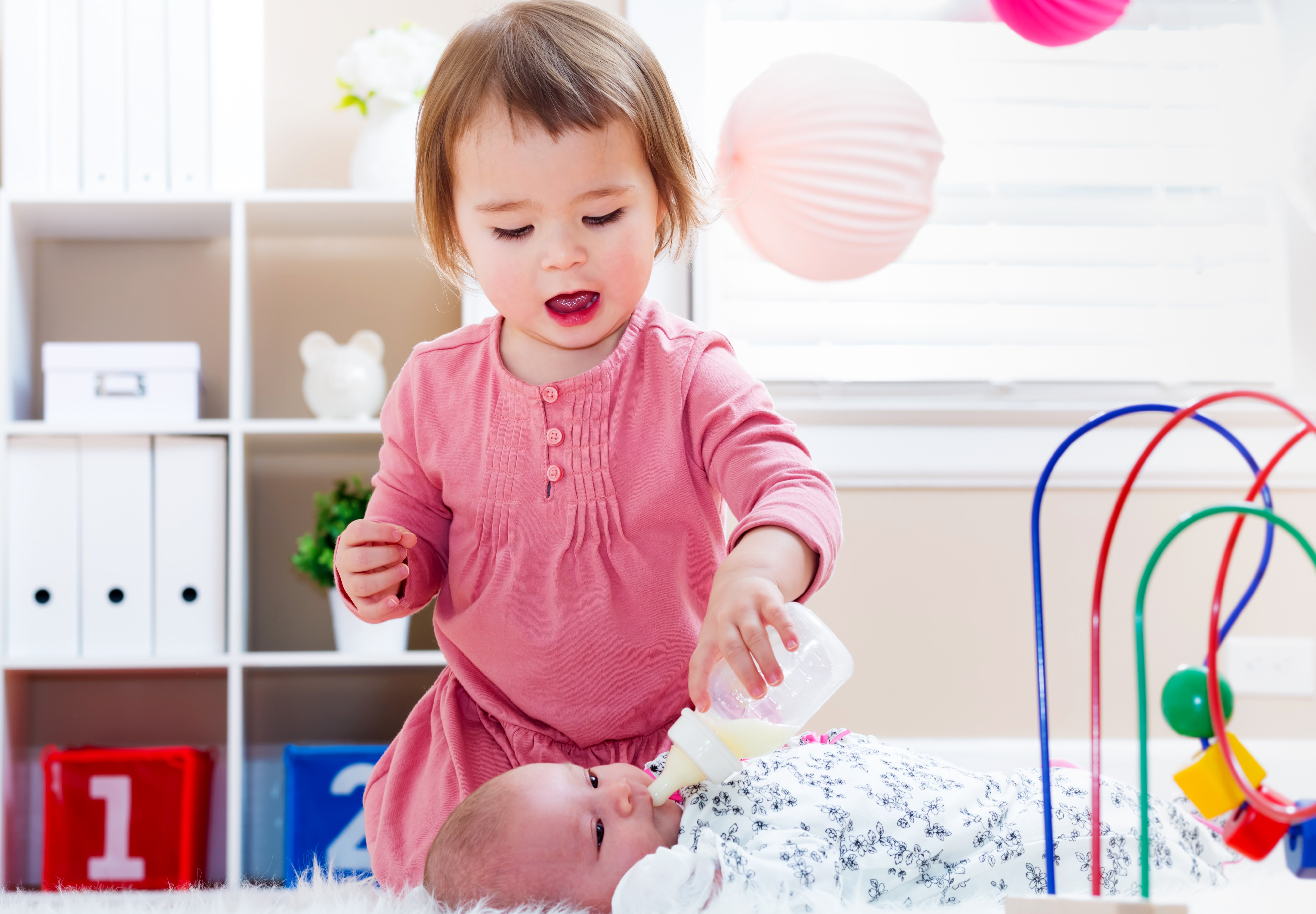 Two little girls feeding a baby HD Wallpaper