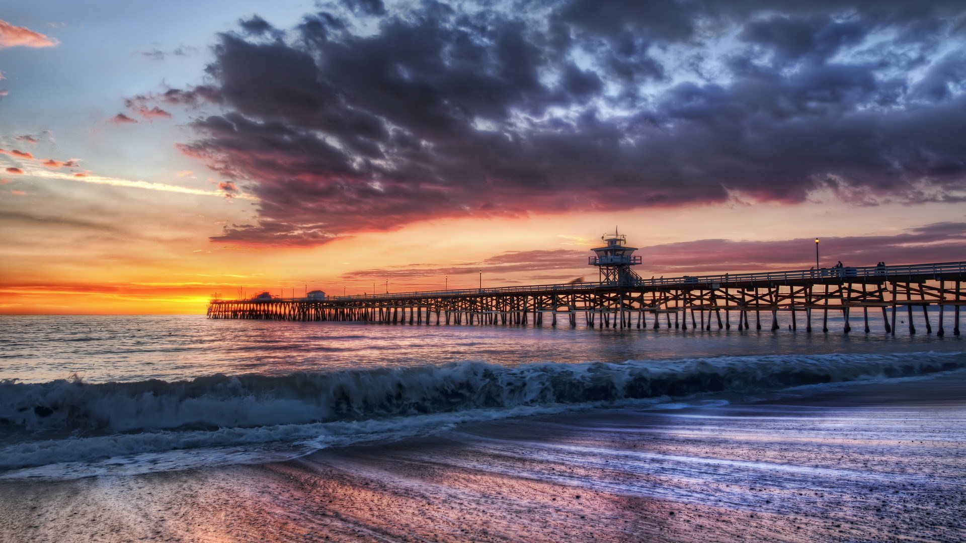 Ocean pier at sunset with dramatic clouds HD Wallpaper
