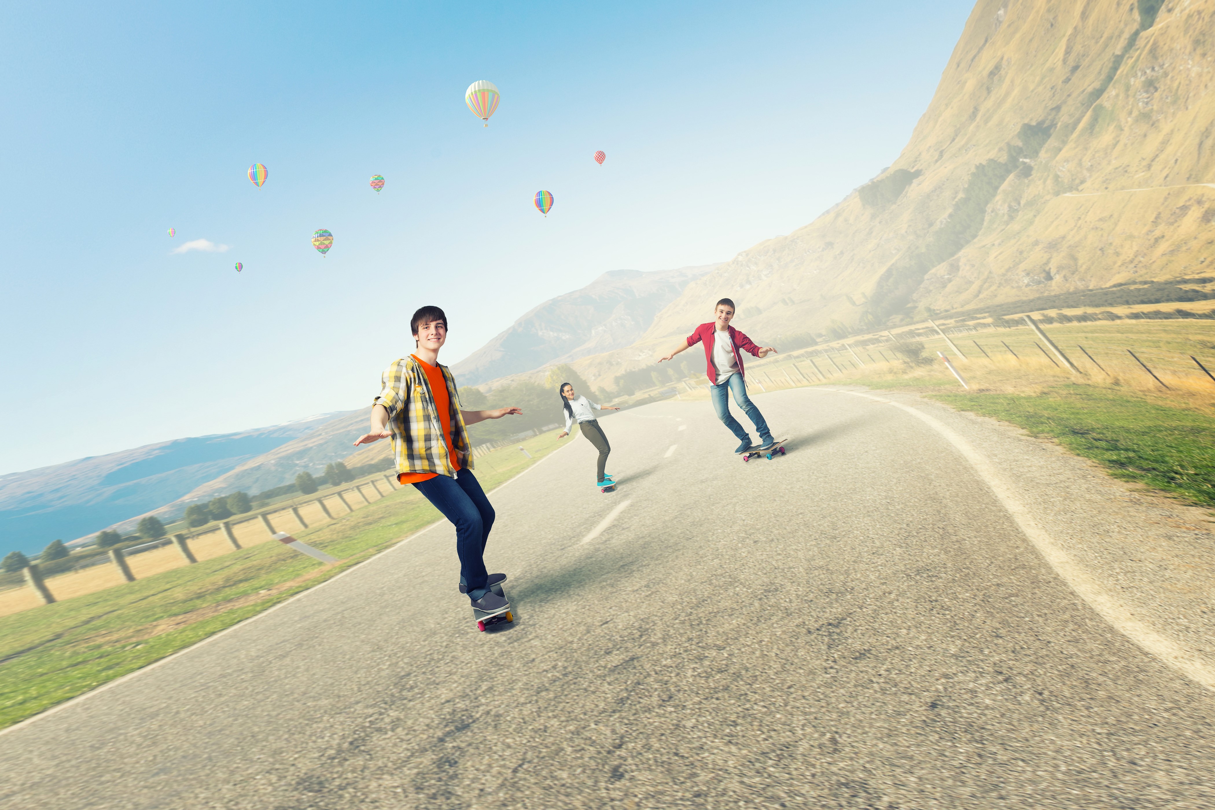 Skateboarding on a Mountain Road with Hot Air Balloons HD Wallpaper