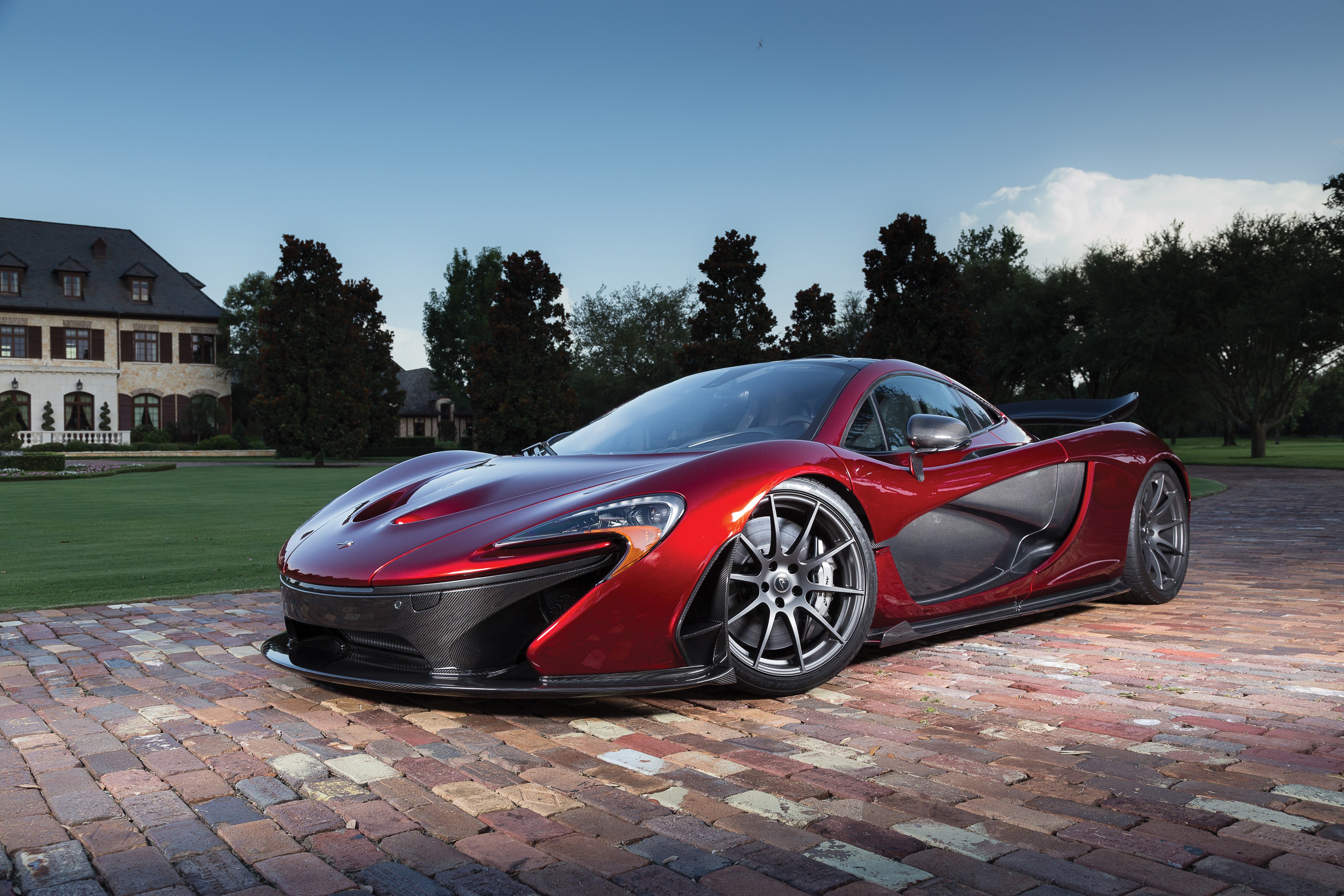 Red McLaren P1 parked on brick driveway HD Wallpaper